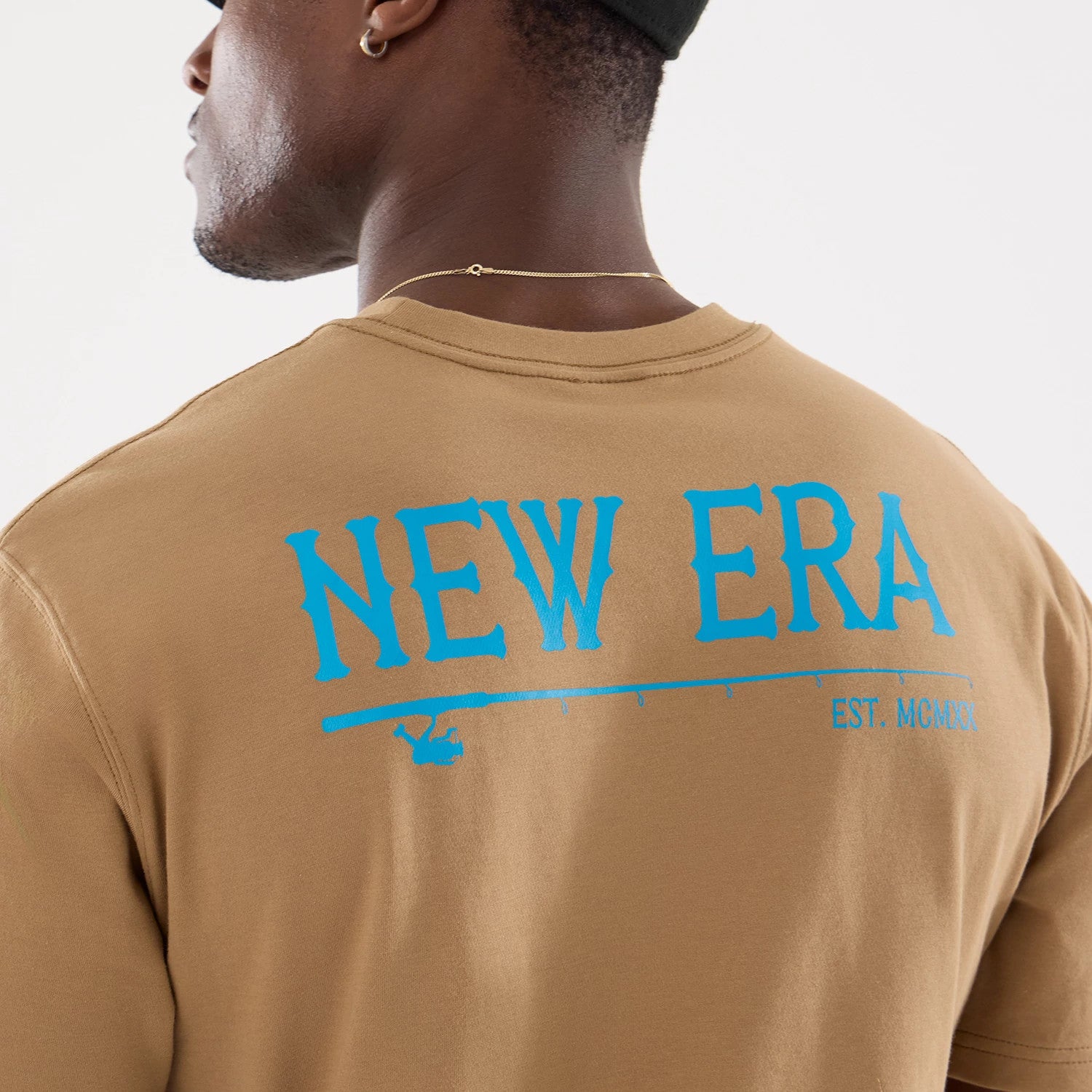 The model is wearing this New Era Outdoor Fishing T-Shirt in Beige. 4