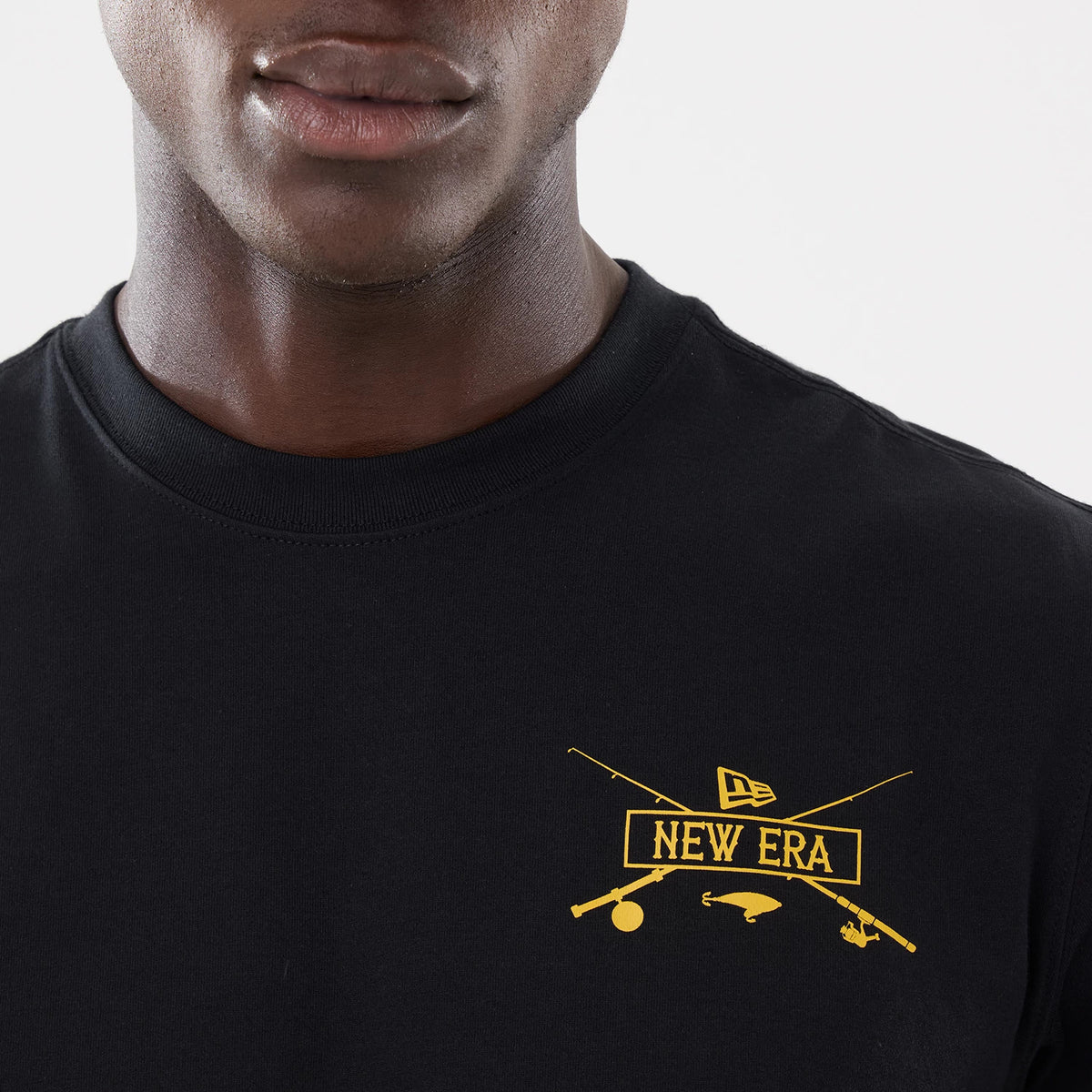 New Era Graphic Outdoor Fishing Black T-Shirt, front view showing the black fabric with a yellow printed graphic of crossed fishing rods, the New Era logo and fishing icons on the chest, round neckline at the top.