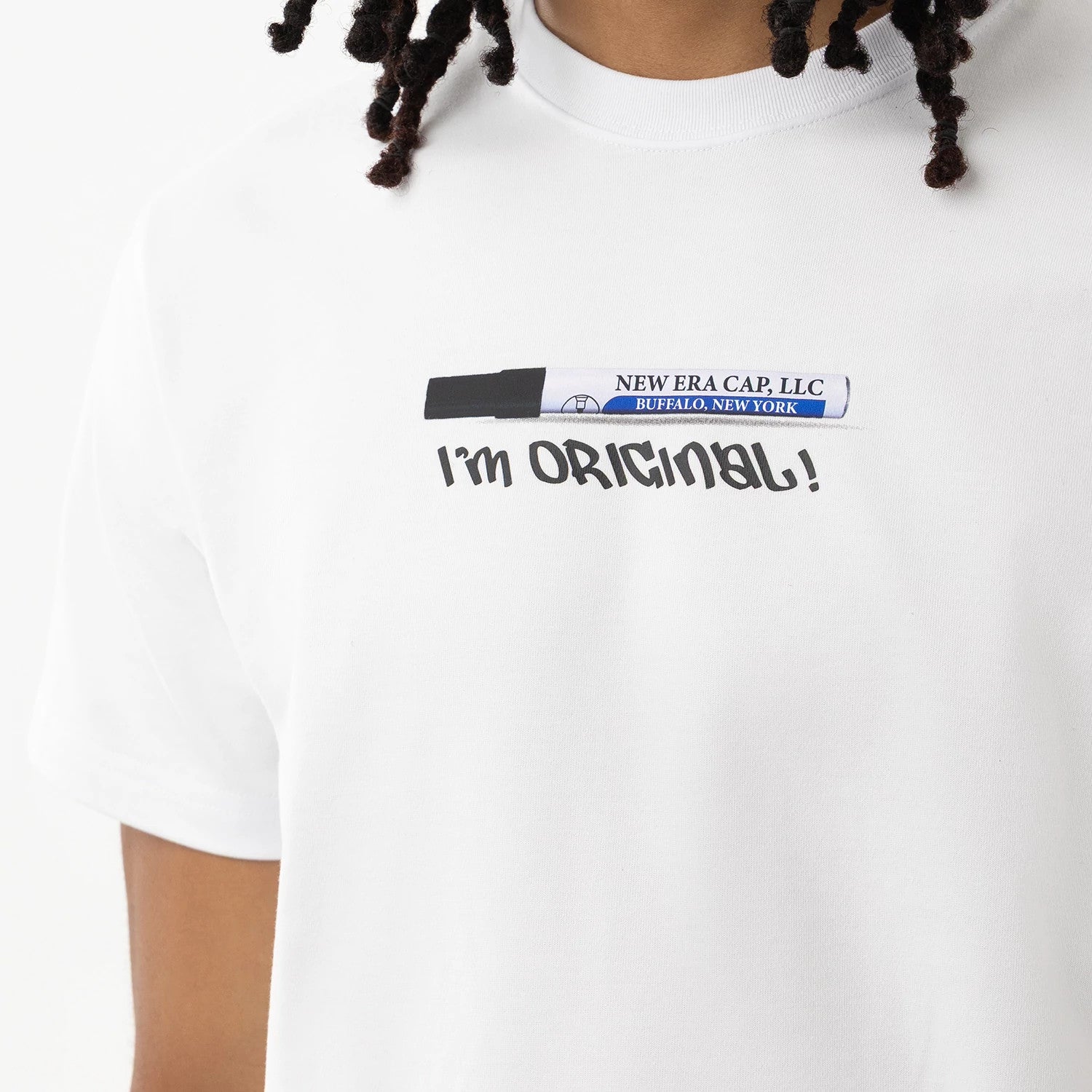 New Era I Am Original White T-Shirt, front view showing a graphic of a black and white marker above the text "I'm Original!" across the chest on the white fabric, worn by a person with cropped hair.