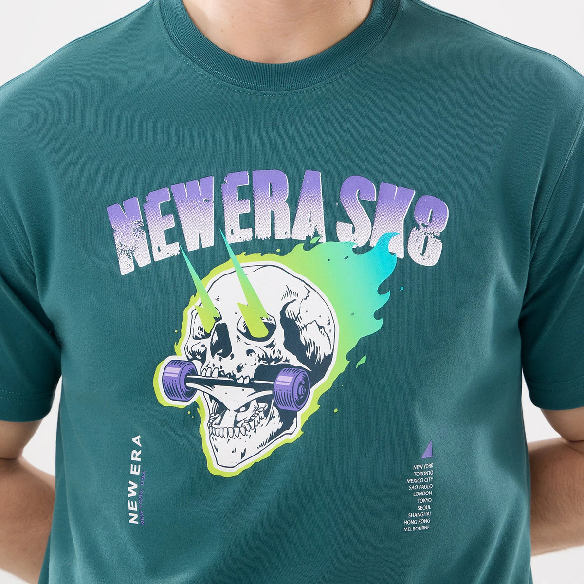 New Era SK8 Graphic Dark Green T-Shirt, front view showing a vibrant graphic of a skull with neon elements across the chest, bold NEW ERA SK8 text above, and a vertical New Era logo printed in white on the lower side.