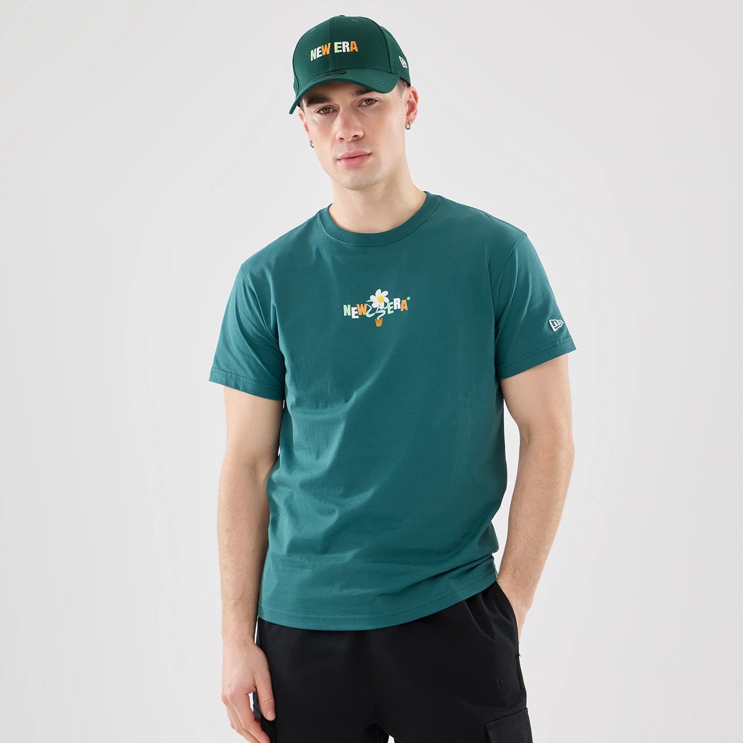The model is wearing this New Era Earth Day T-Shirt in dark green. 1