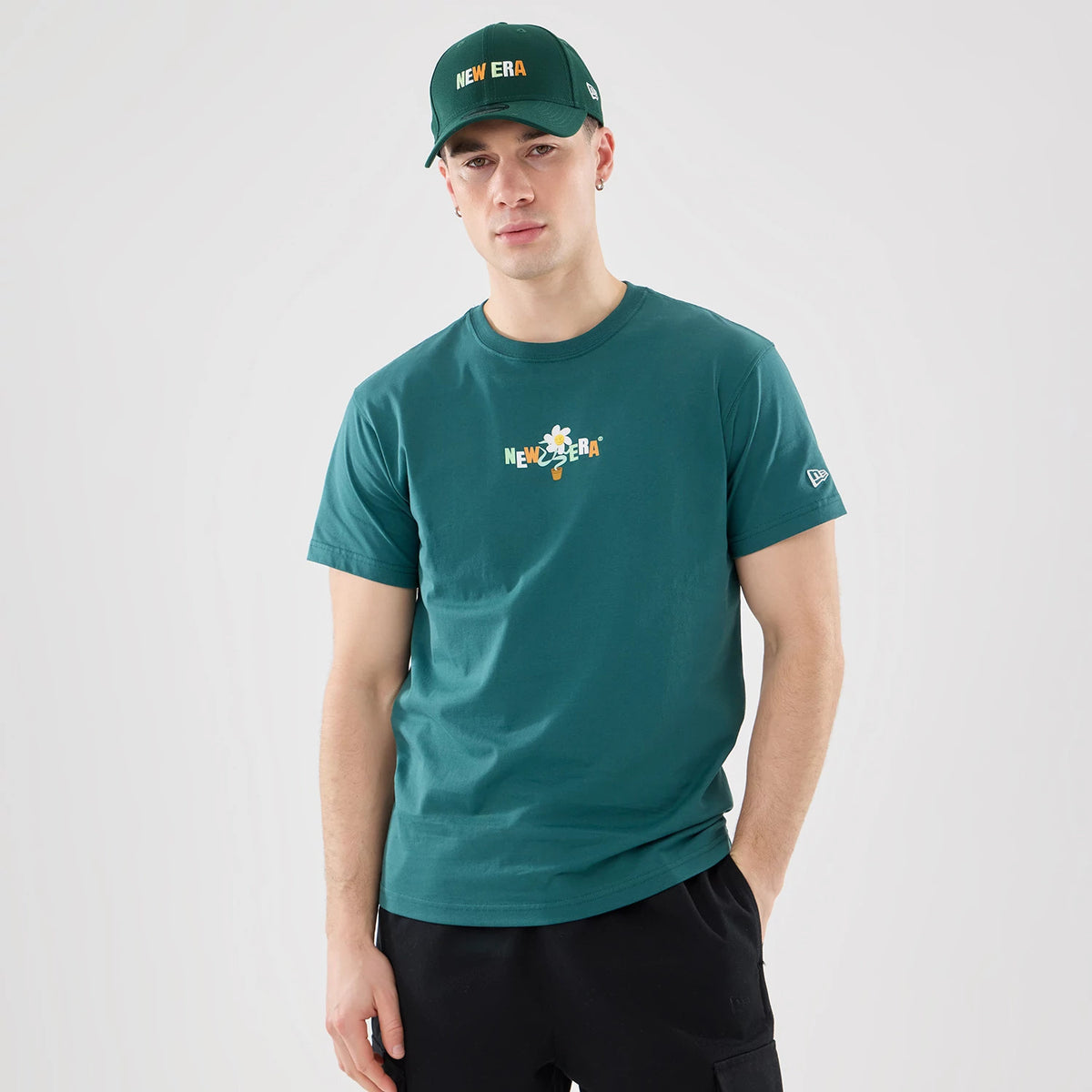 The model is wearing this New Era Earth Day T-Shirt in dark green. 1
