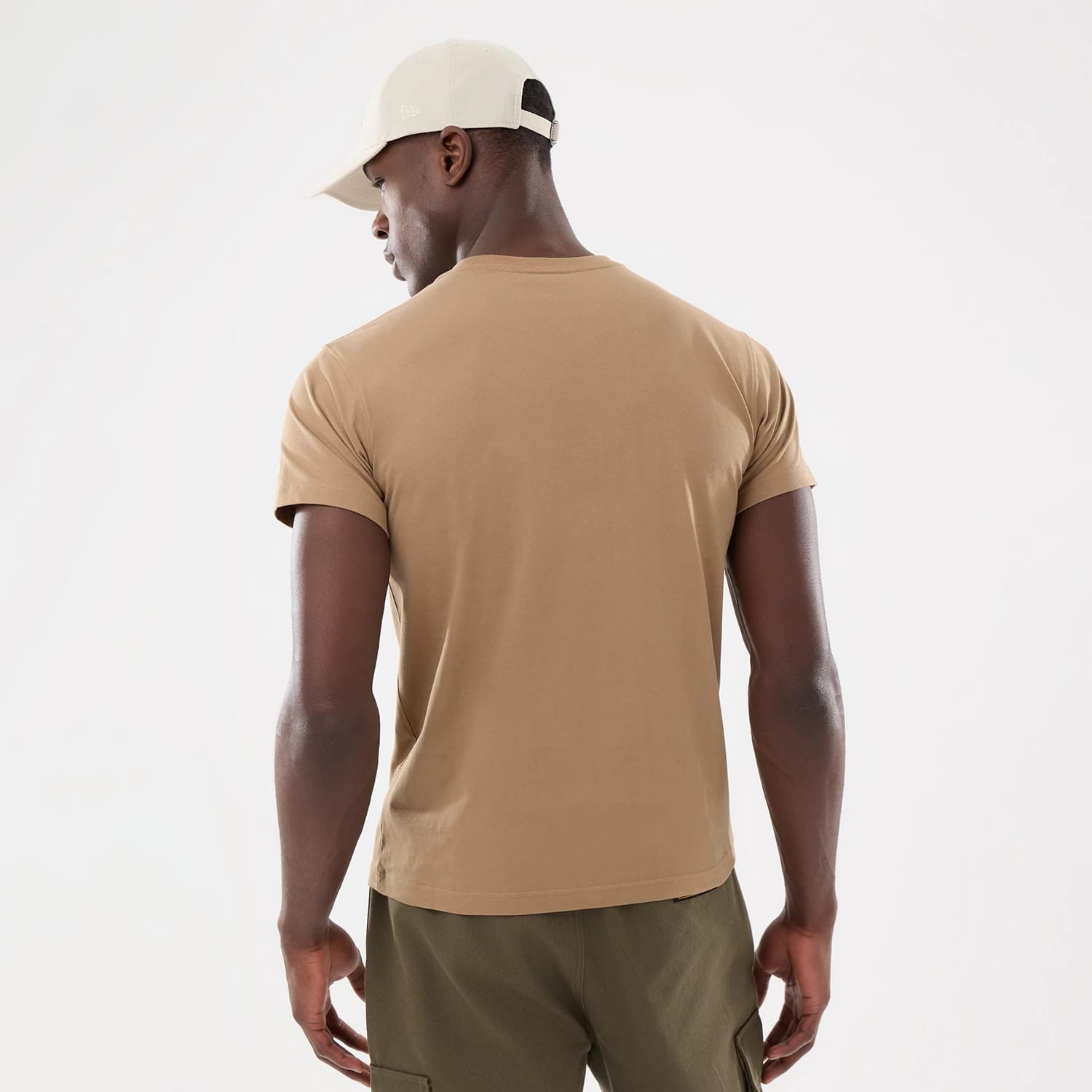 New Era Earth Day Beige T-Shirt, on-model view from the back showing the plain beige short sleeves and crew neck design, model wearing an off-white cap with a debossed logo on the side.