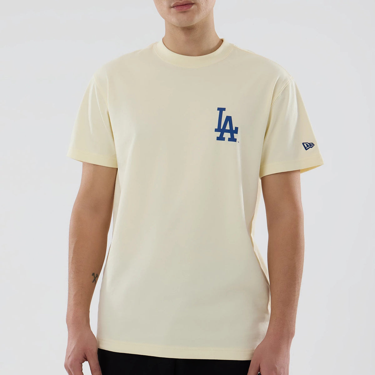 LA Dodgers MLB City Series Cream T-Shirt, front view showing a cream body with a blue embroidered LA Dodgers logo on the left chest and a small New Era logo patch on the left sleeve.