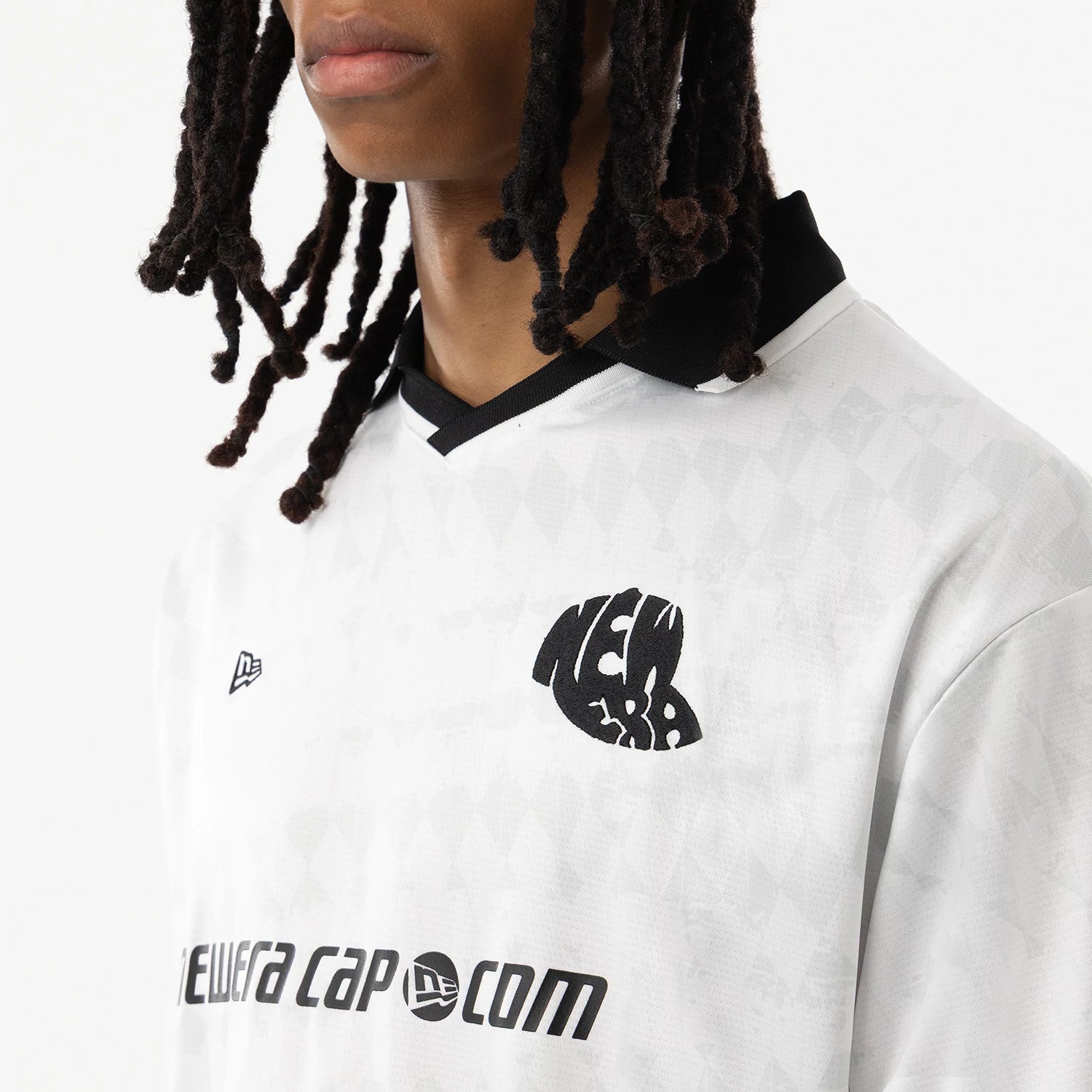 New Era White Soccer Jersey, front view on a model showing black New Era chest logo, black collar, and black section design print, with matching black text branding across the lower front.