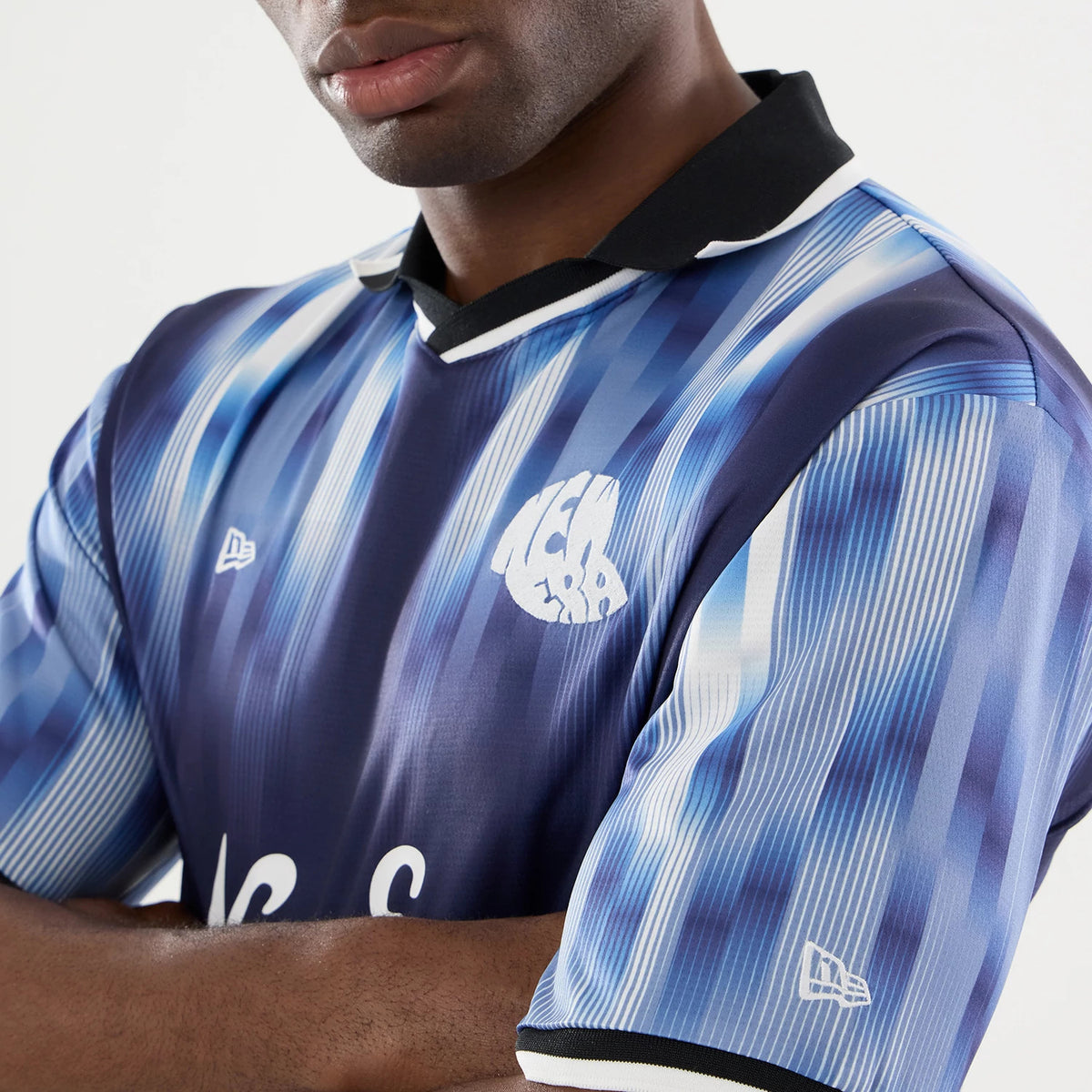 New Era Navy Soccer Jersey, close-up on a model showing blue and white vertical stripes with a black collar, featuring the New Era flag logo on the right chest and a white NEA 2023 graphic on the left.