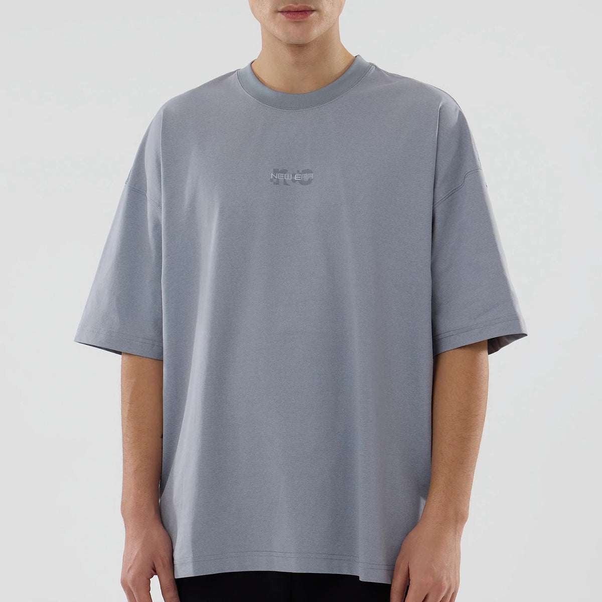 New Era NEC Logo Grey Oversized T-Shirt, front view showing the relaxed fit grey shirt with short sleeves and a small raised New Era logo centred on the chest below the round neckline.