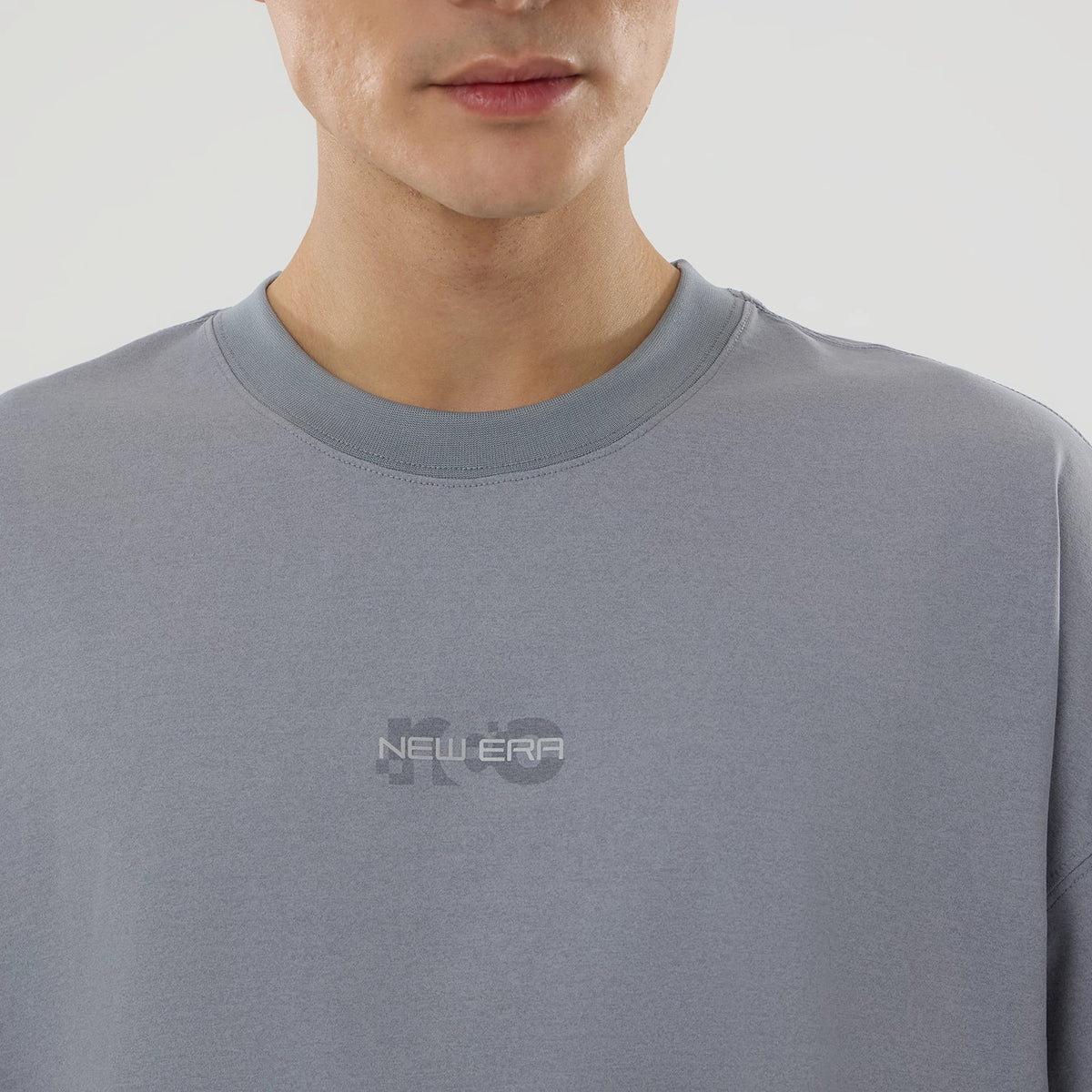 New Era NEC Logo Grey Oversized T-Shirt, front view showing a grey oversized t-shirt with a raised New Era logo on the chest, rounded neckline and smooth drape across the shoulders.