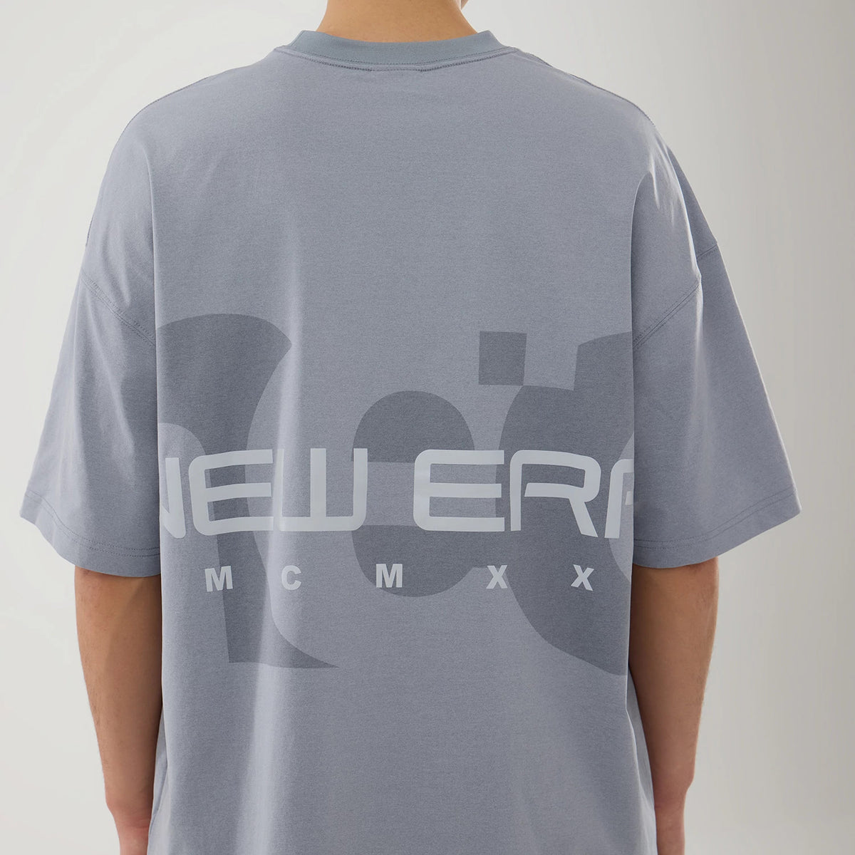 New Era NEC Logo Grey Oversized T-Shirt, rear view showing a grey oversized fit with a large printed New Era logo and bold graphic design across the back, extending from shoulder to shoulder.