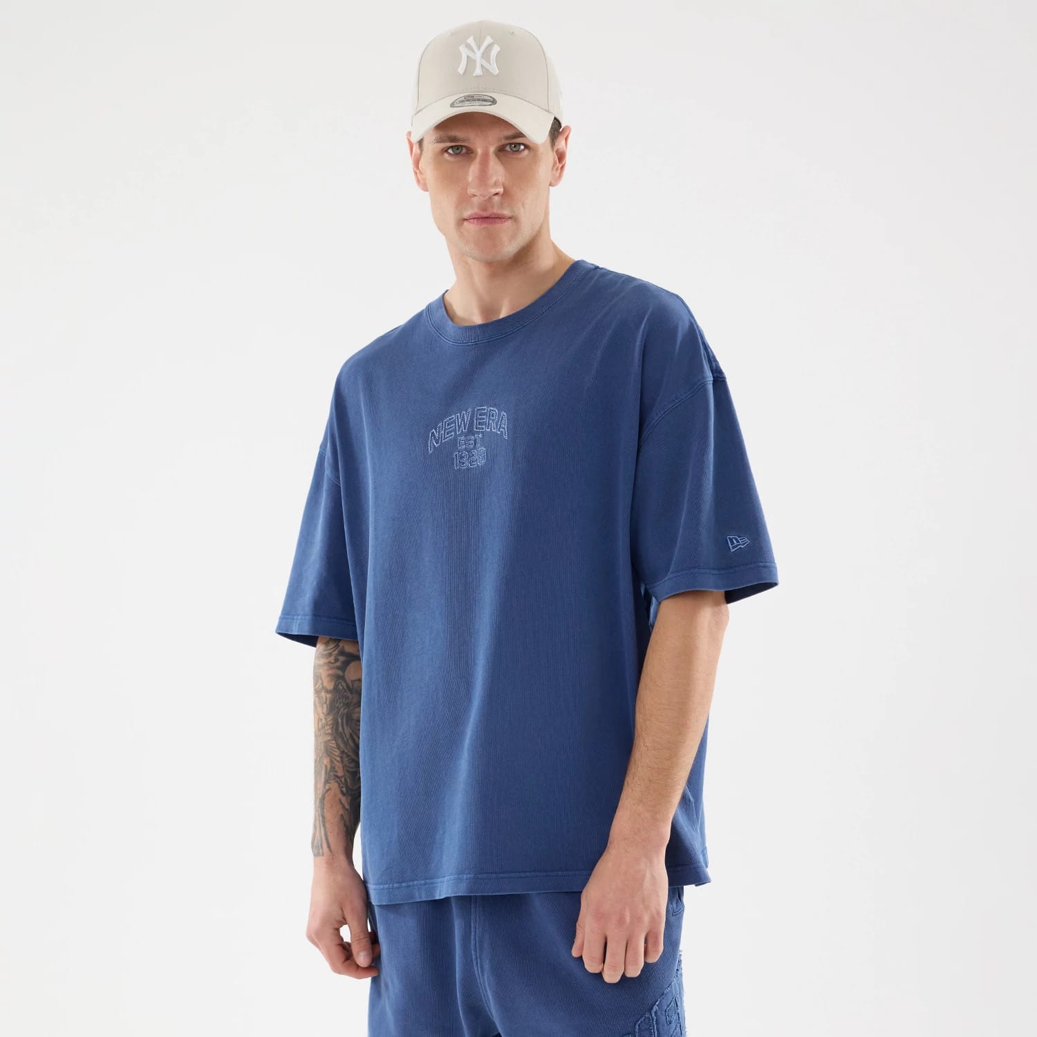 The model is wearing this New Era Street Archived Oversized T-Shirt in blue. 1