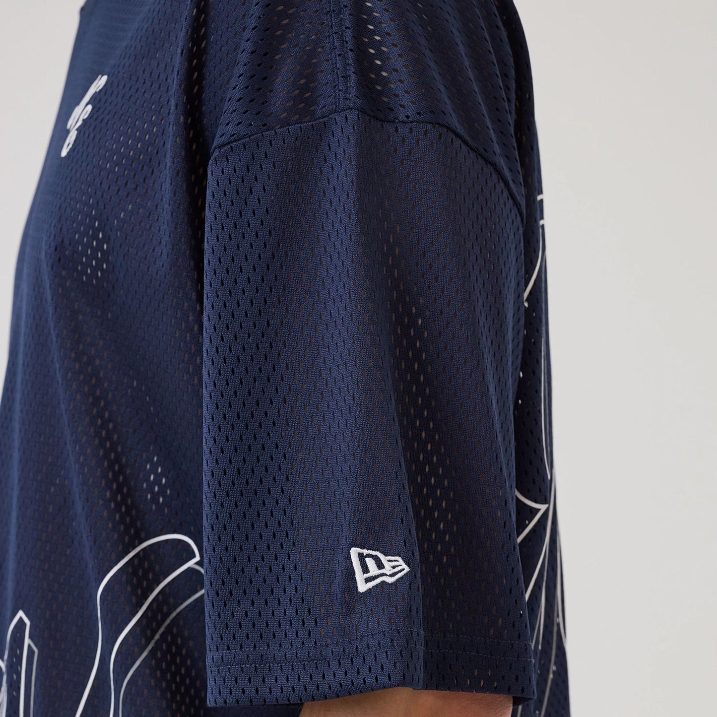 The model is wearing this New Era Mix League Oversized Mesh T-Shirt in blue. 7