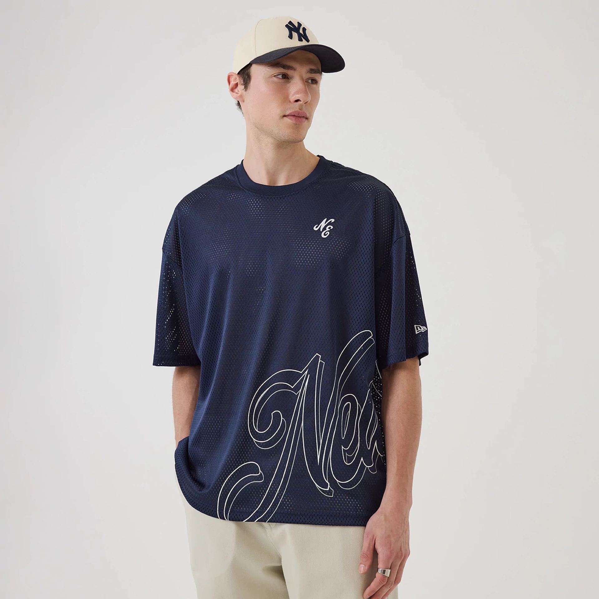 The model is wearing this New Era Mix League Oversized Mesh T-Shirt in blue. 1