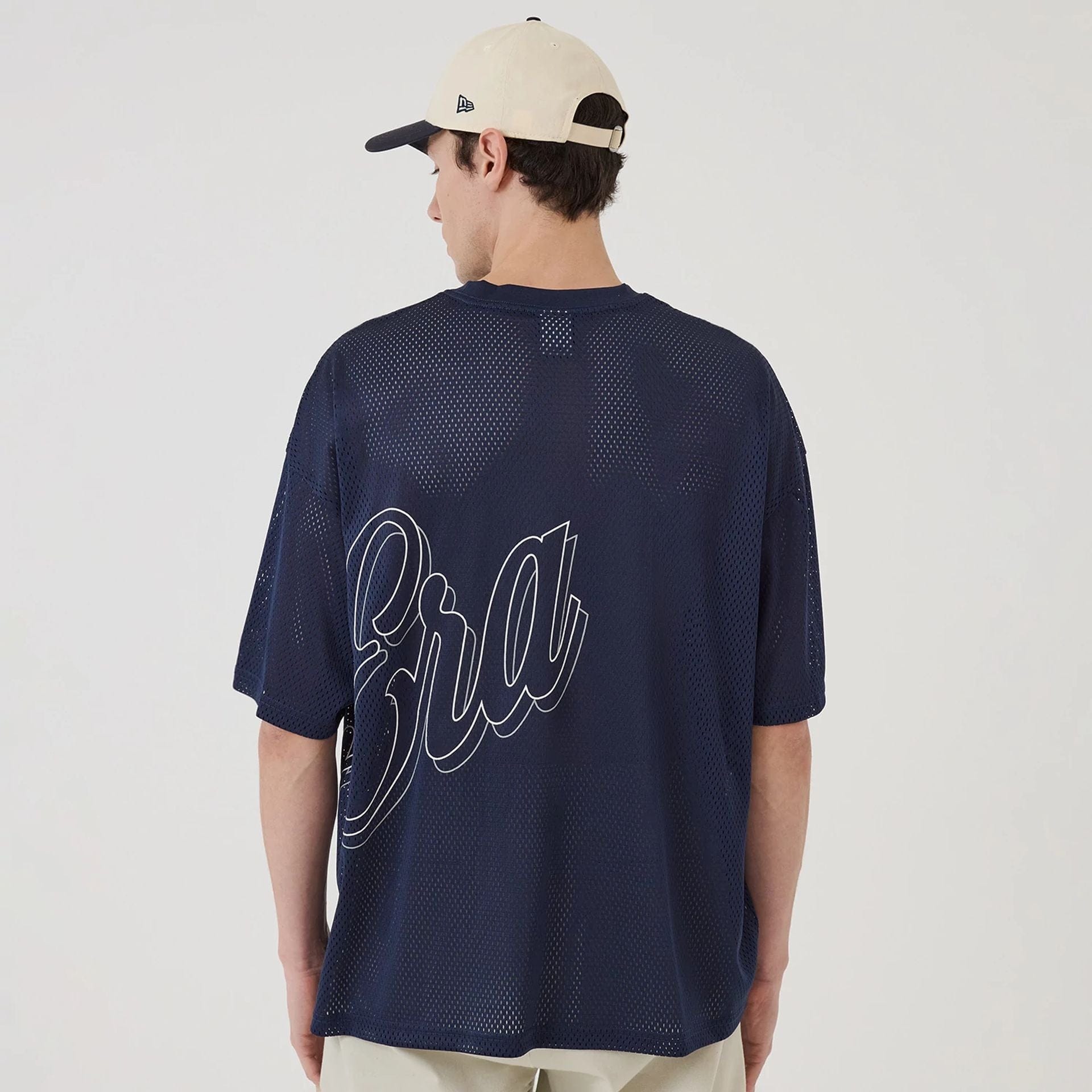 The model is wearing this New Era Mix League Oversized Mesh T-Shirt in blue. 2