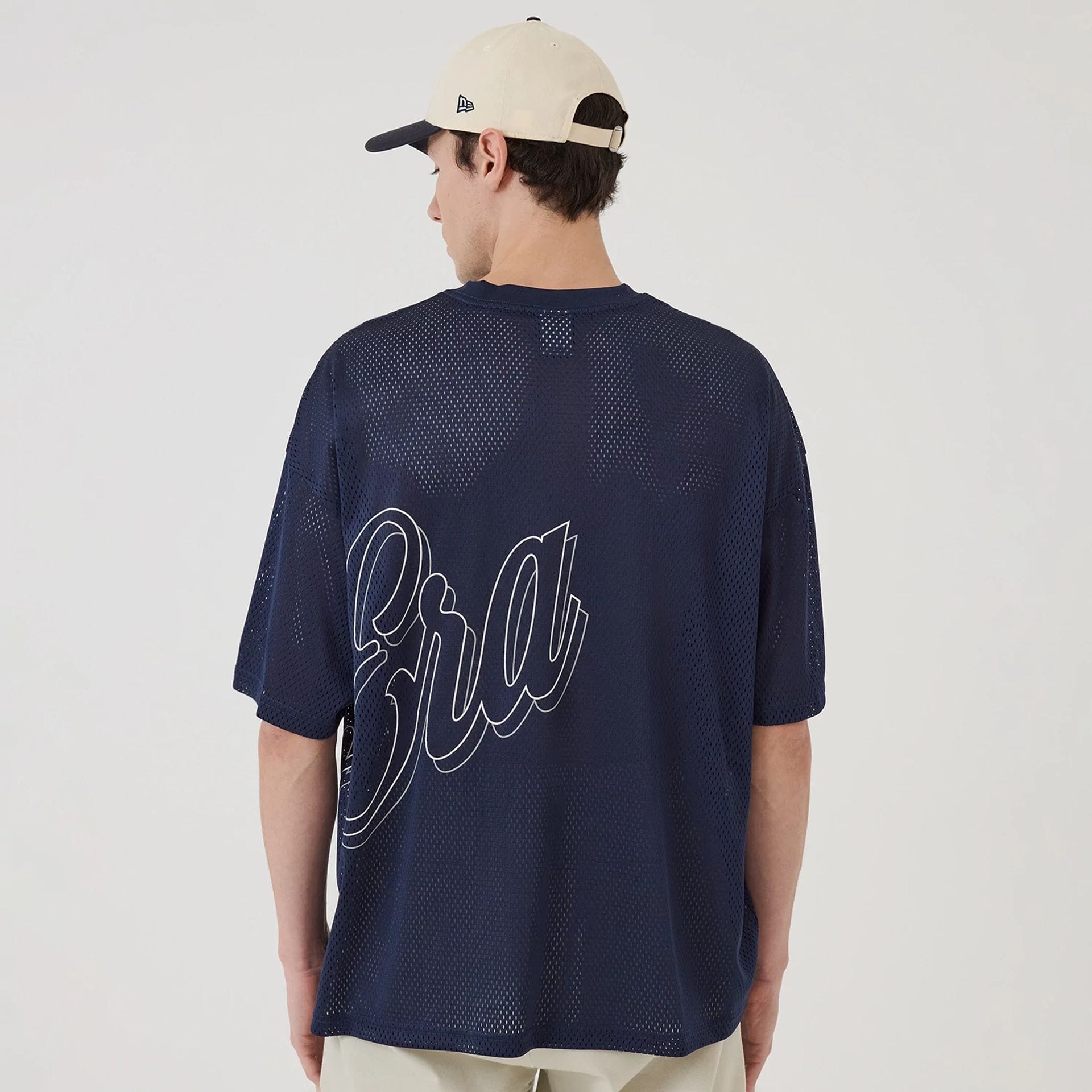 The model is wearing this New Era Mix League Oversized Mesh T-Shirt in blue. 2