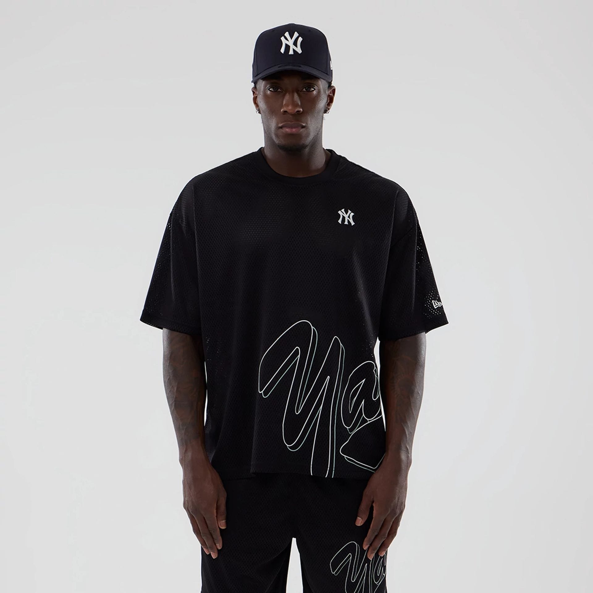The model is wearing this MLB Mix League New York Yankees Oversized Mesh T-Shirt in black. 1