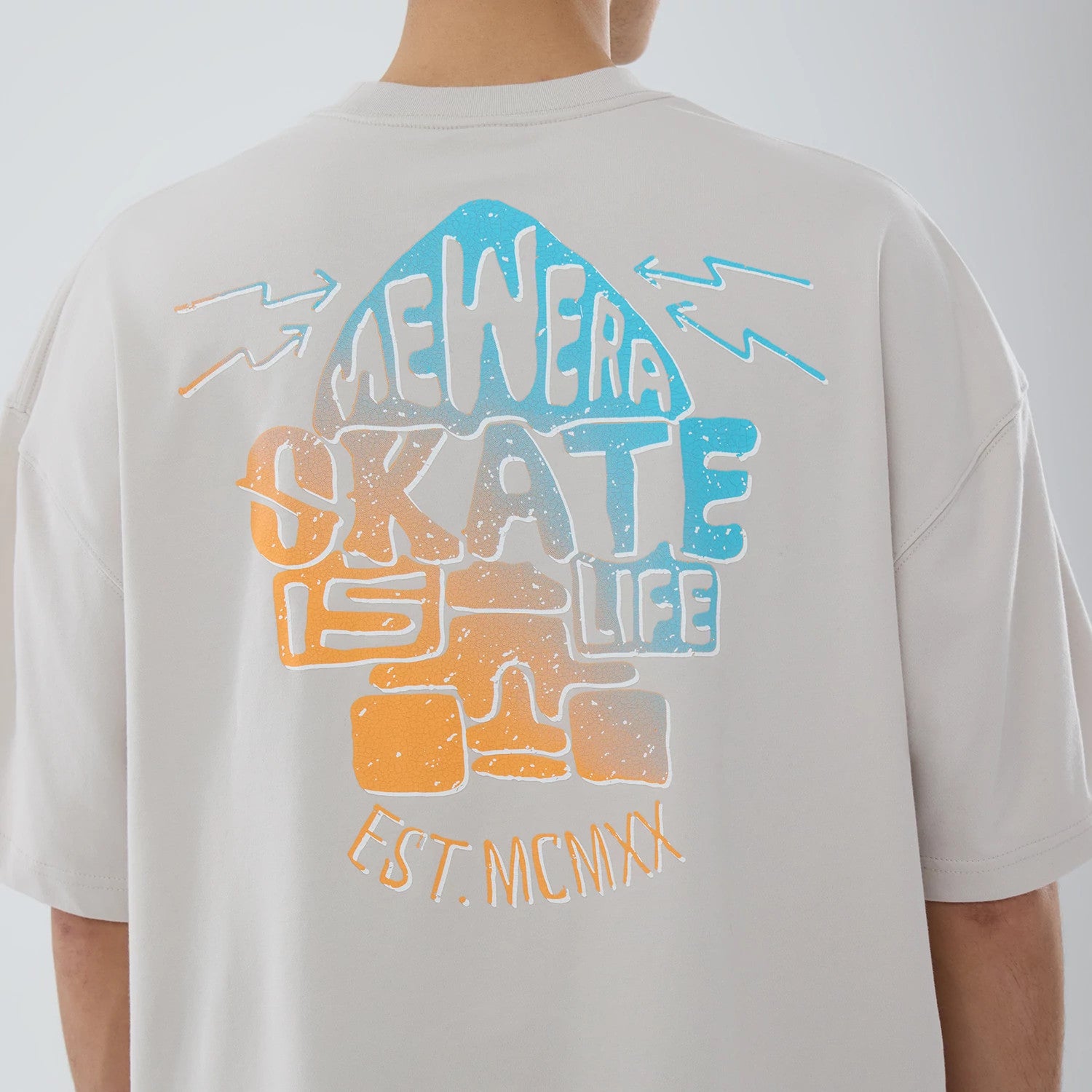 The model is wearing this New Era Skate Is Life Graphic Oversized T-Shirt in Cream. 4