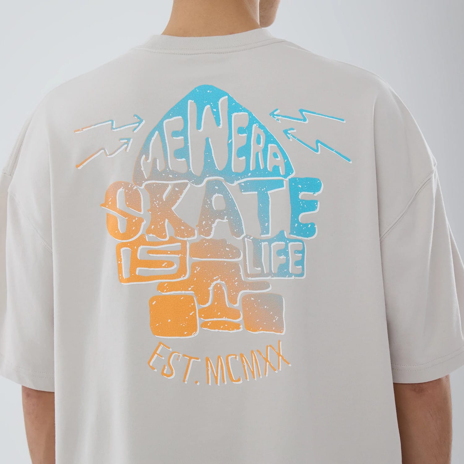 The model is wearing this New Era Skate Is Life Graphic Oversized T-Shirt in Cream. 4