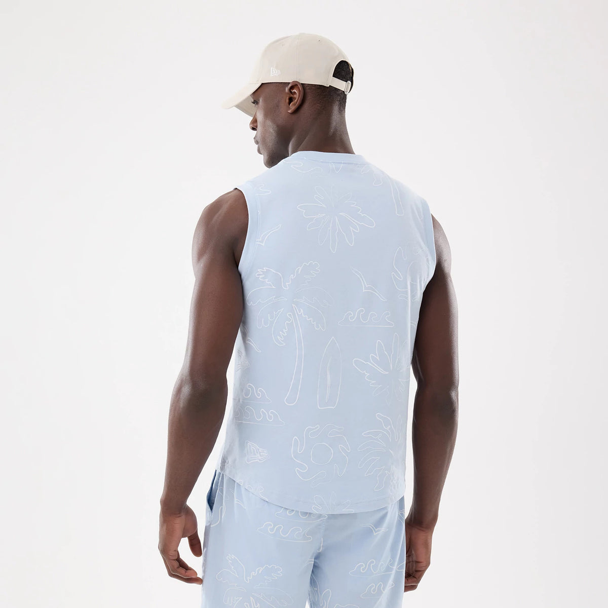 New Era Resort Blue Tank Top, back view on a model wearing matching shorts and a cap, featuring subtle palm tree and wave patterns, with a clean sleeveless design and comfortable loose fit.