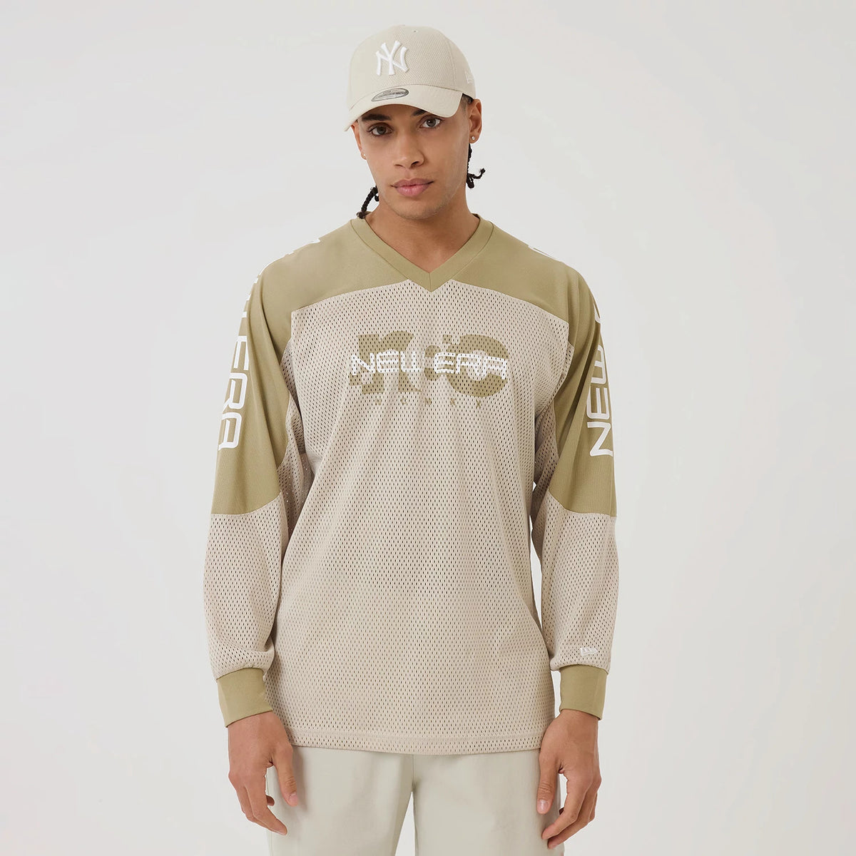 The model is wearing this New Era NEC Logo Long Sleeve Jersey in beige/khaki. 1
