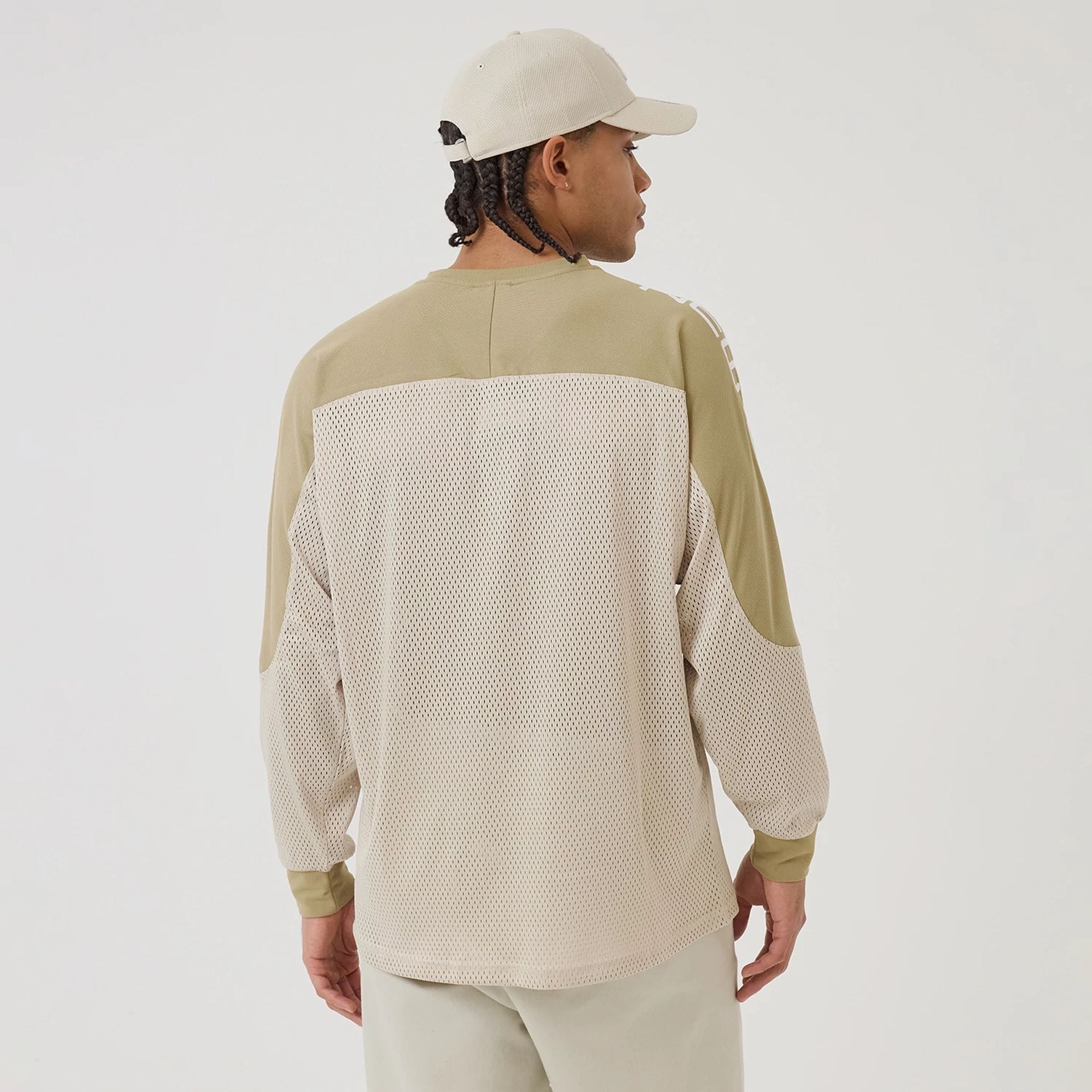 The model is wearing this New Era NEC Logo Long Sleeve Jersey in beige/khaki. 2