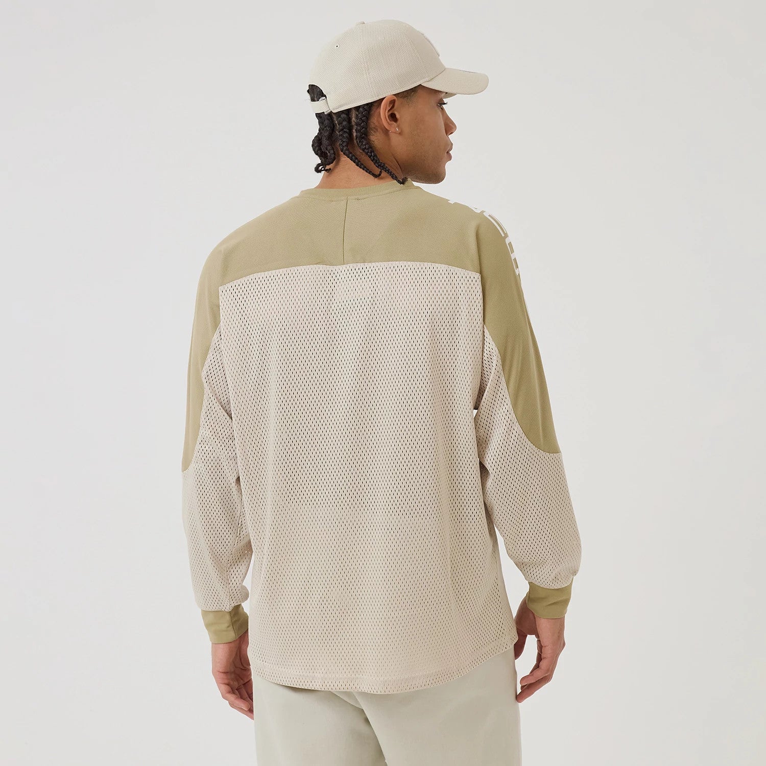 New Era NEC Logo Beige Long Sleeve Jersey, back view on a model wearing a beige cap, featuring mesh fabric on the lower back and sleeves, and contrasting solid beige panels across the shoulders and elbows.