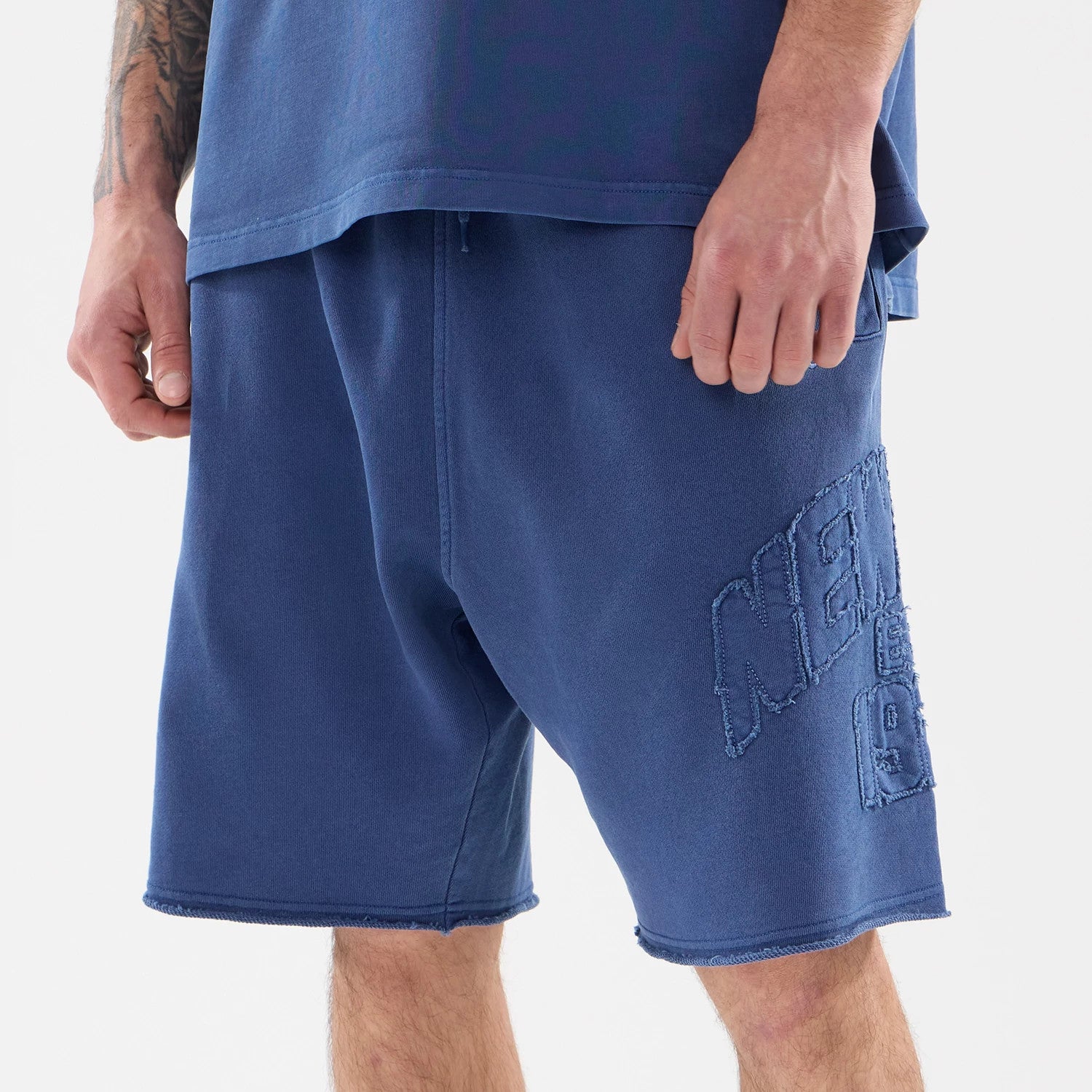 The model is wearing this New Era Street Archived Oversized Shorts in blue. 3