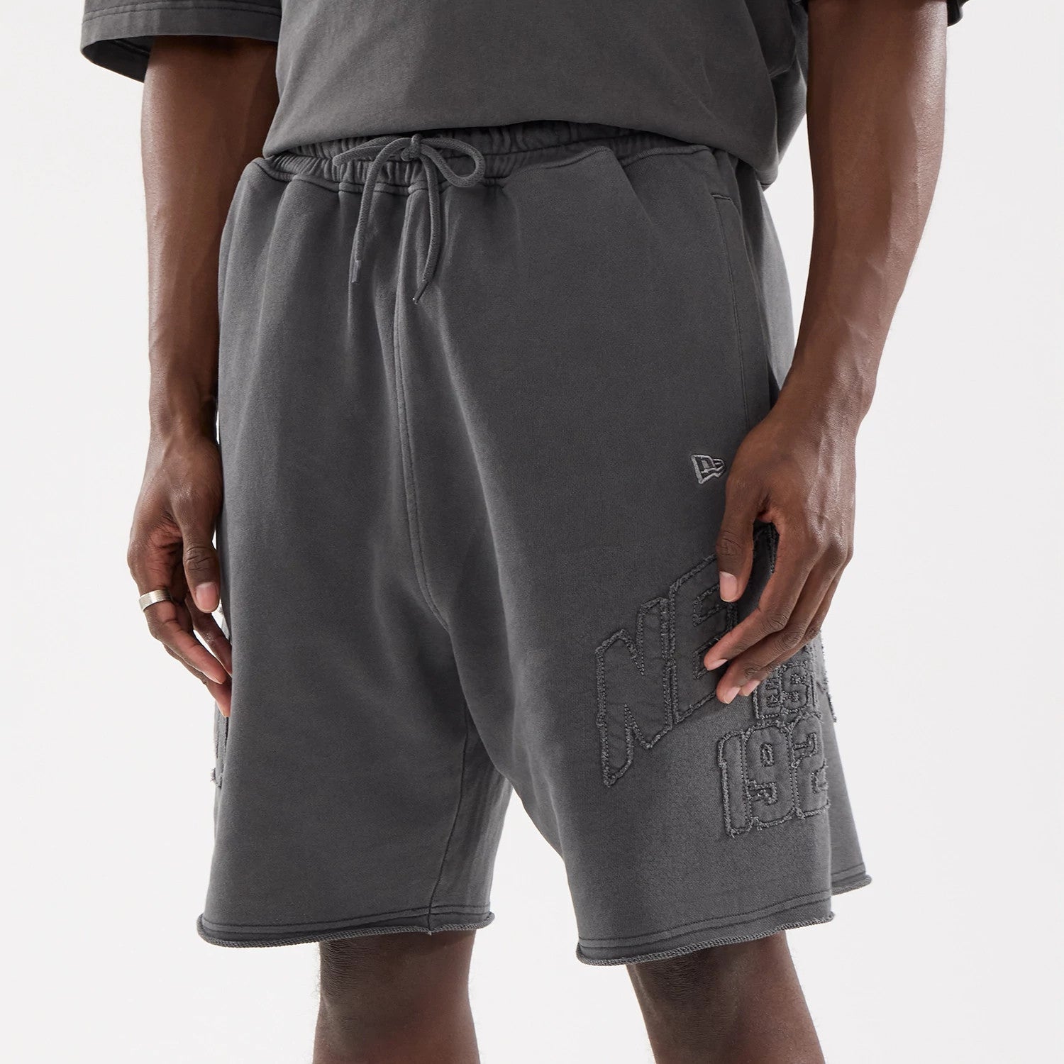 The model is wearing this New Era Street Archived Oversized Shorts in black. 3