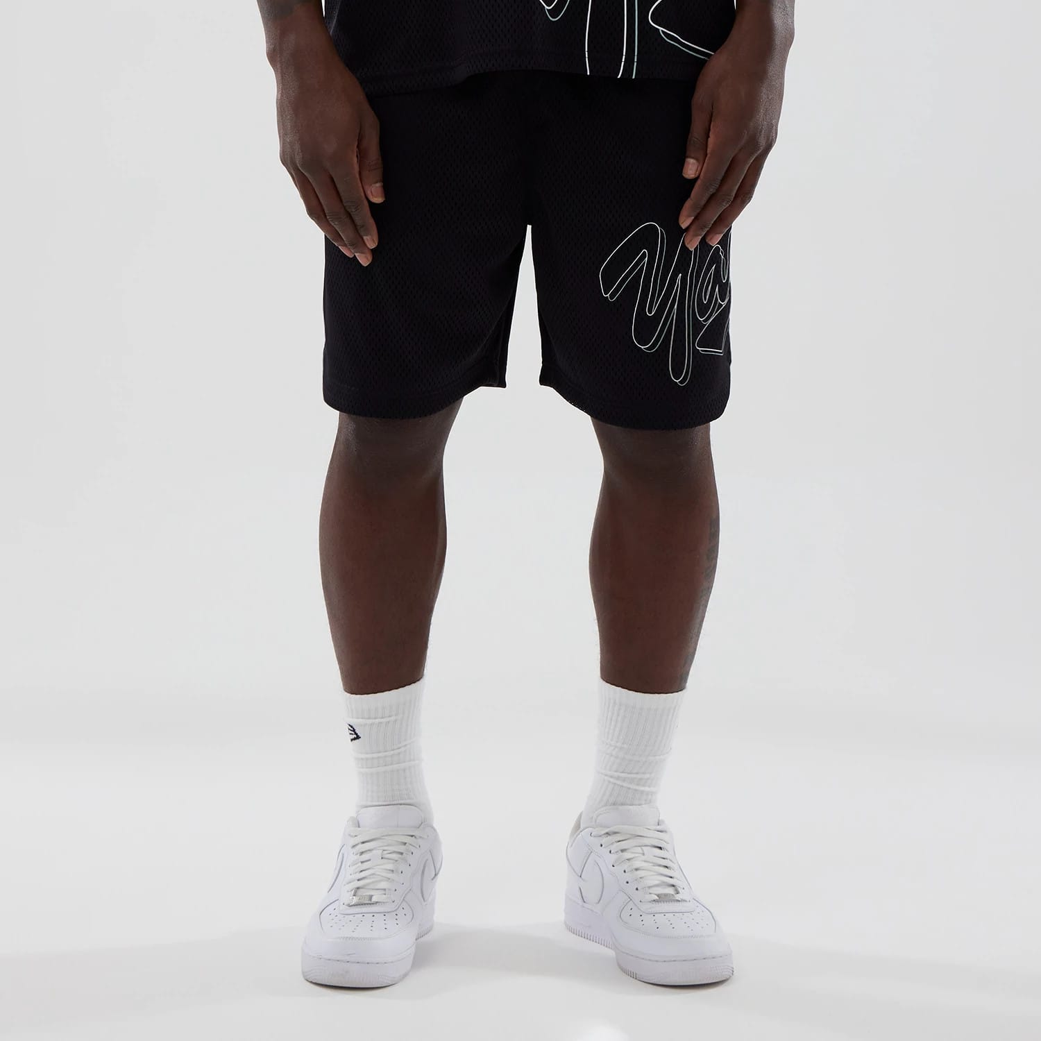 The model is wearing this MLB Mix League New York Yankees Oversized Mesh Shorts in black. 1