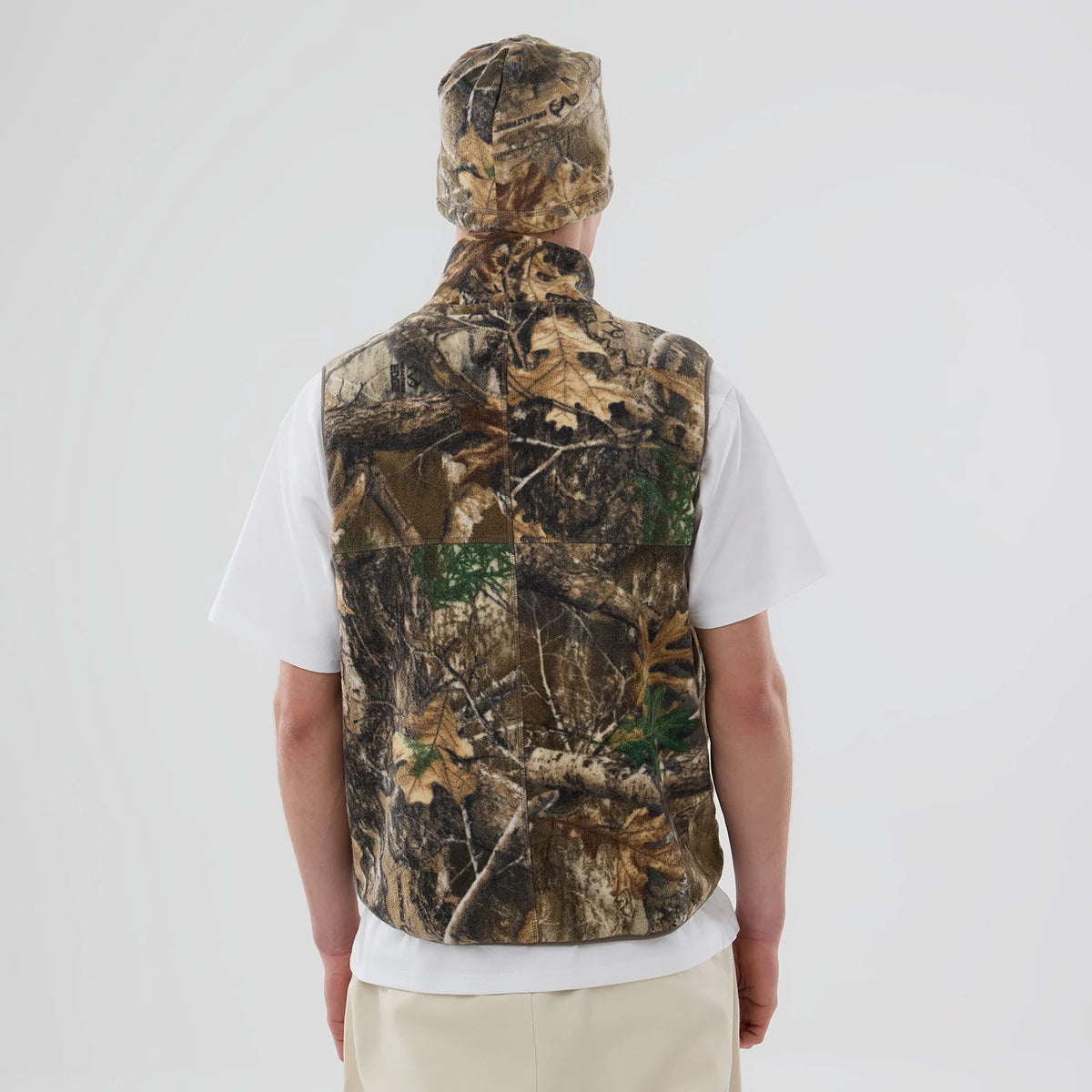 The model is wearing this Thisisneverthat X New Era Revolution Fleece Vest in Real Tree. 2