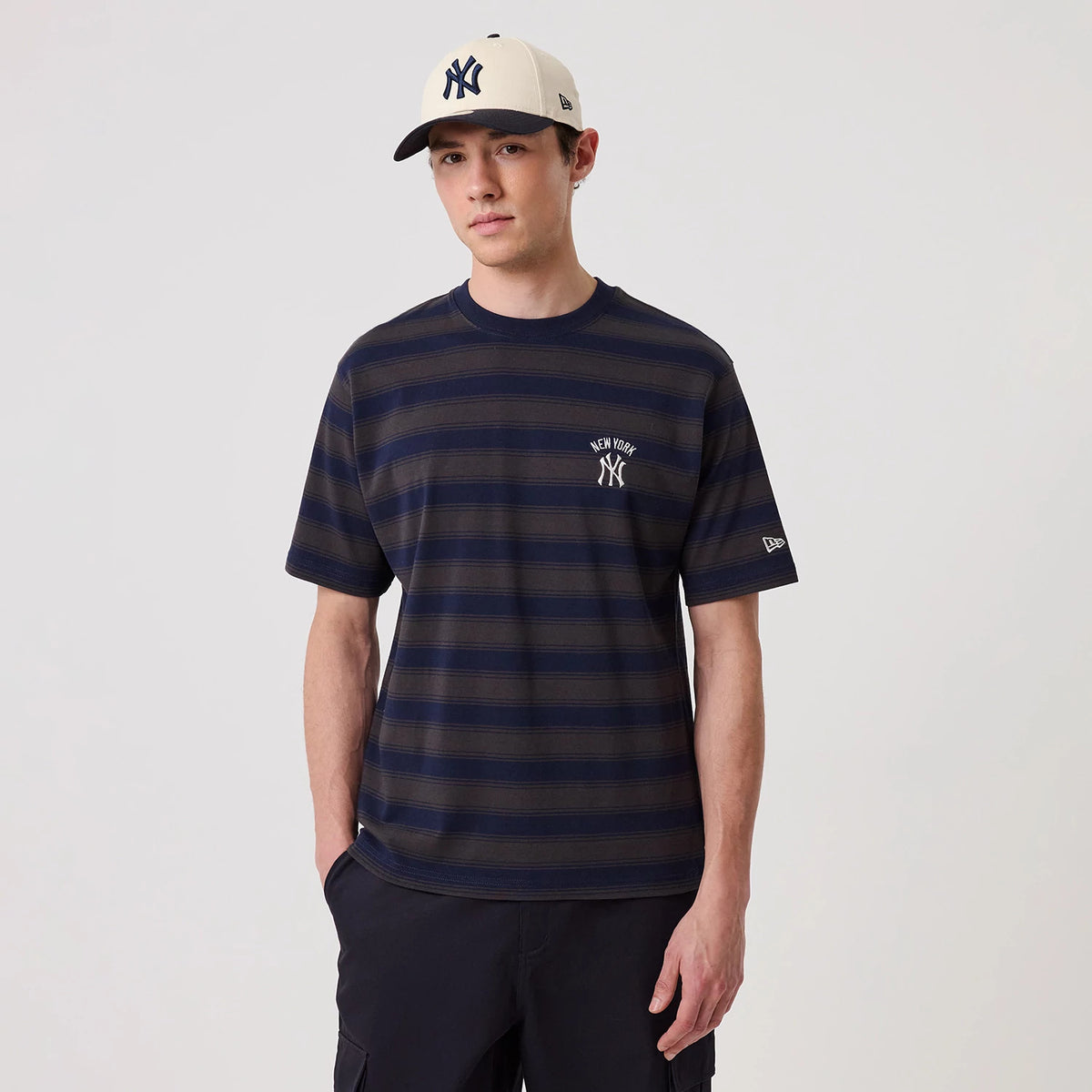 New York Yankees MLB Border Navy Oversized T-Shirt, on-model view showing a navy striped tee with an embroidered white New York Yankees logo on the chest and a separate embroidered New Era logo on the left sleeve.