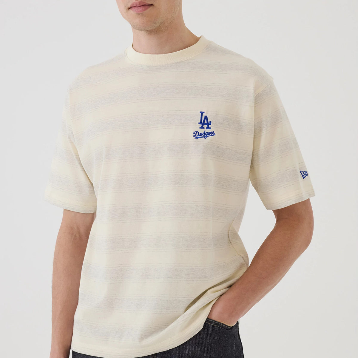 LA Dodgers MLB Border Cream Oversized T-Shirt, front view showing the embroidered blue LA Dodgers logo on the left chest, cream stripes across the fabric, and a New Era logo on the left sleeve.