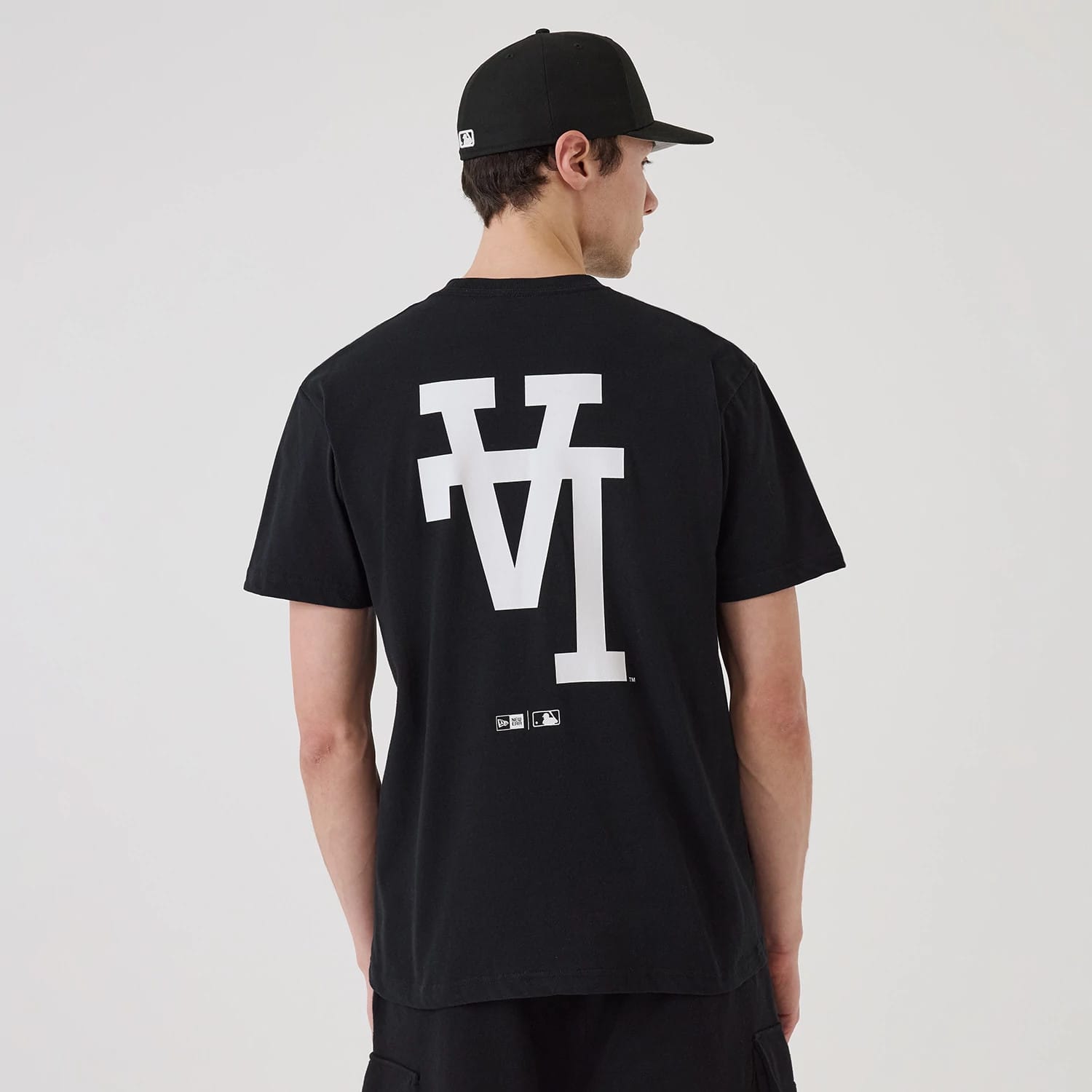 LA Dodgers MLB Upside Down Black T-Shirt, rear view showing a large white upside-down LA logo printed in the centre of the black fabric, with small MLB and New Era logos positioned below it near the hem.