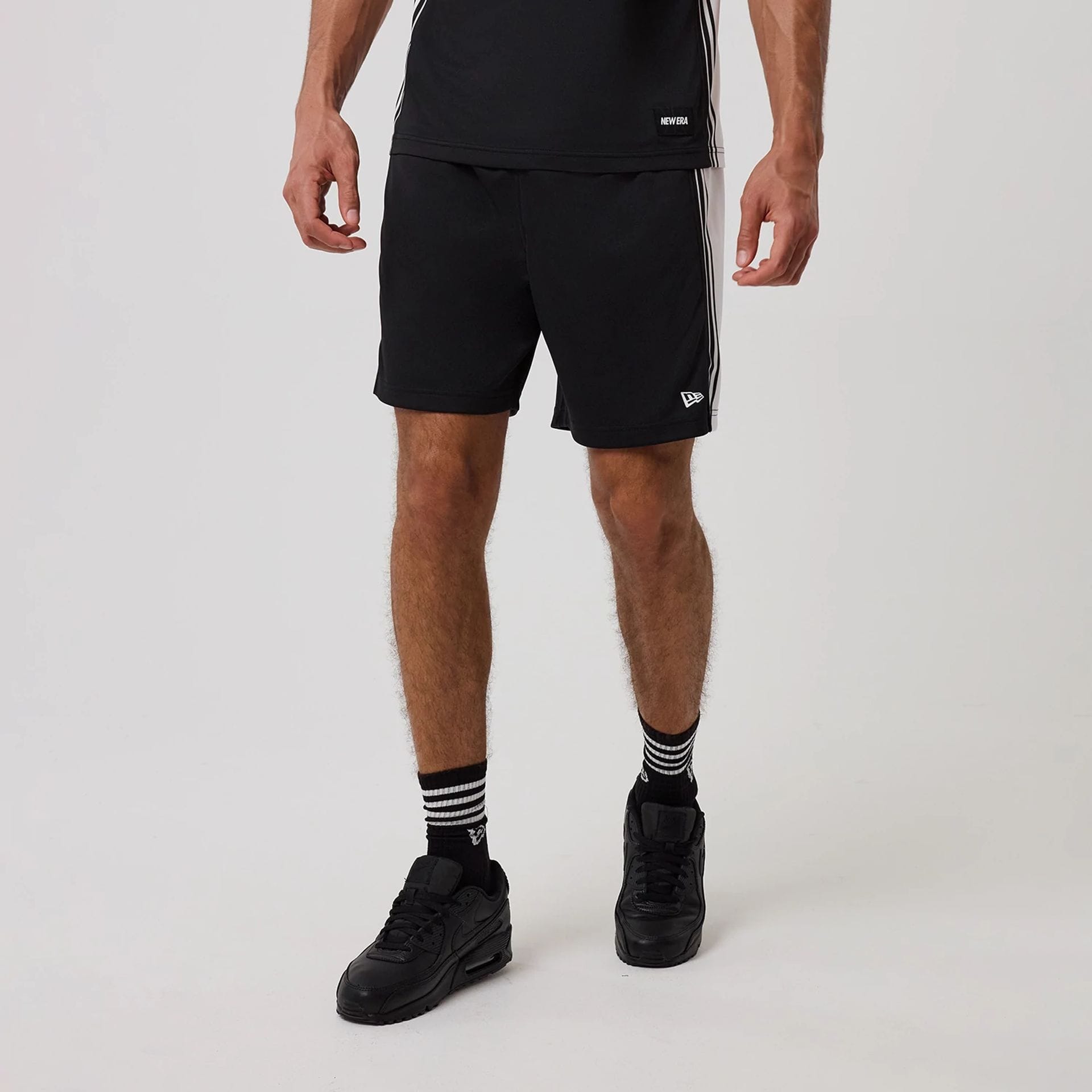 The model is wearing this New Era Mesh Oversized Shorts in black. 1