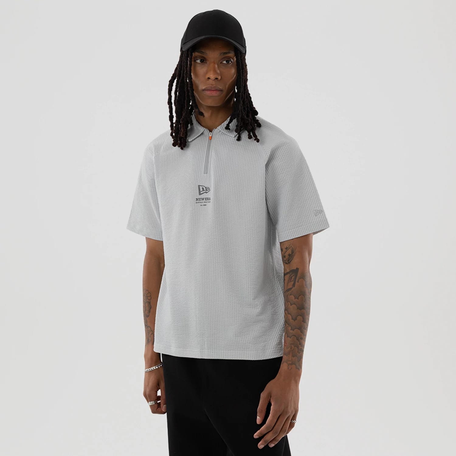 The model is wearing this New Era Seersucker Polo T-Shirt in grey. 1