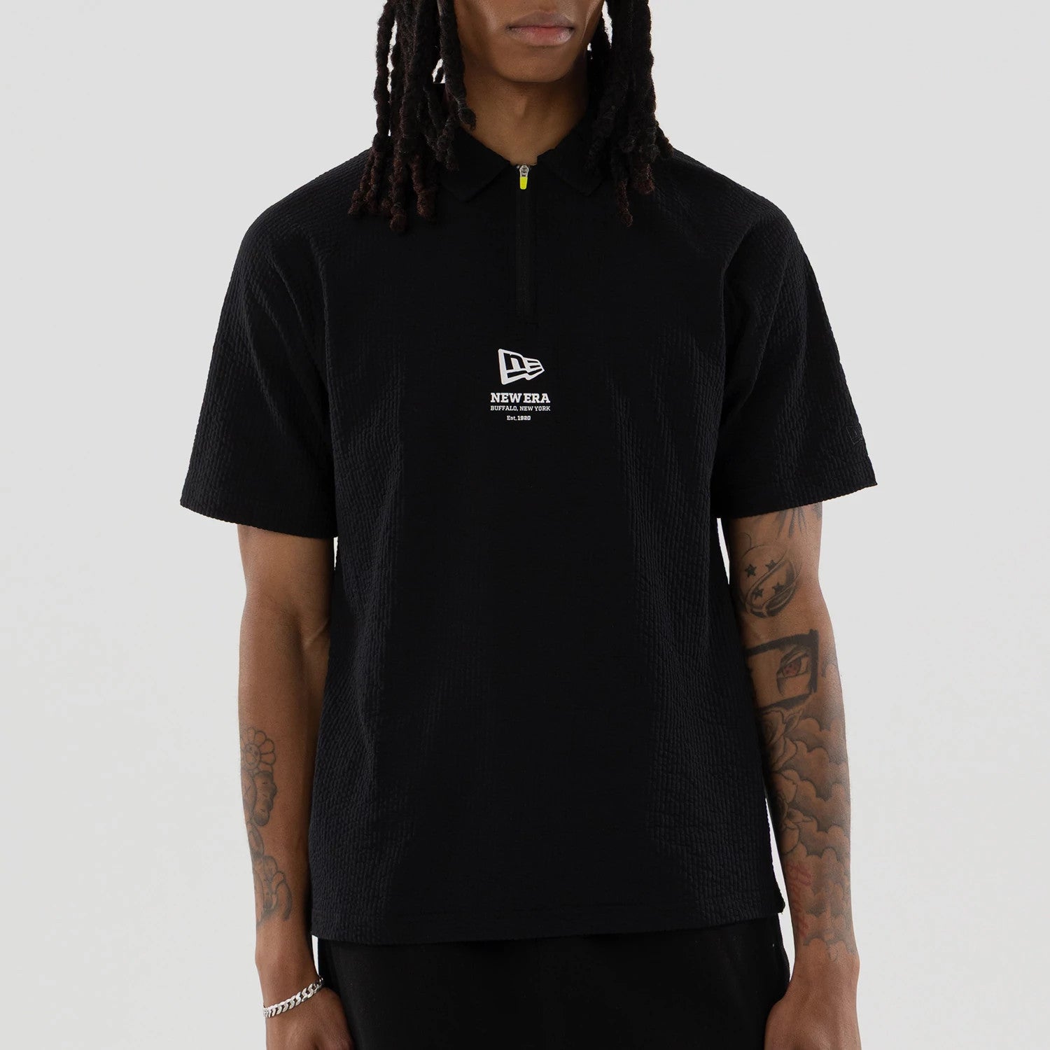 The model is wearing this New Era Seersucker Polo T-Shirt in black. 3