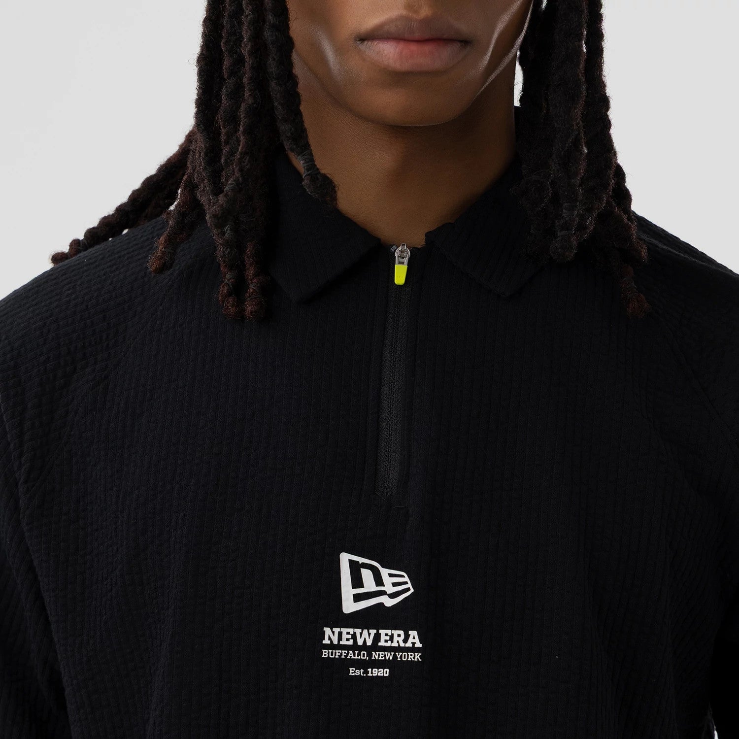 The model is wearing this New Era Seersucker Polo T-Shirt in black. 4