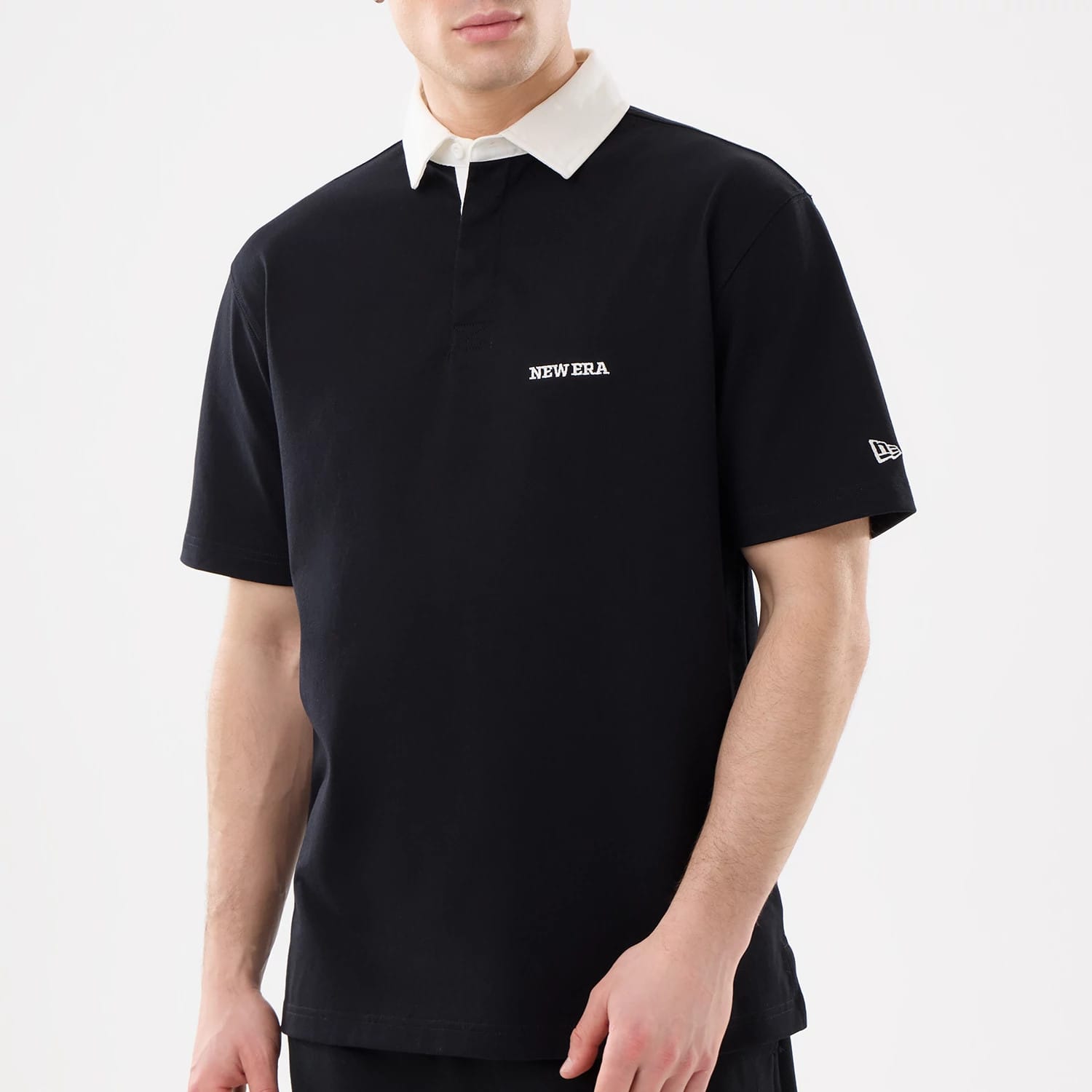 The model is wearing this New Era Short Sleeve Rugby Shirt in black. 3