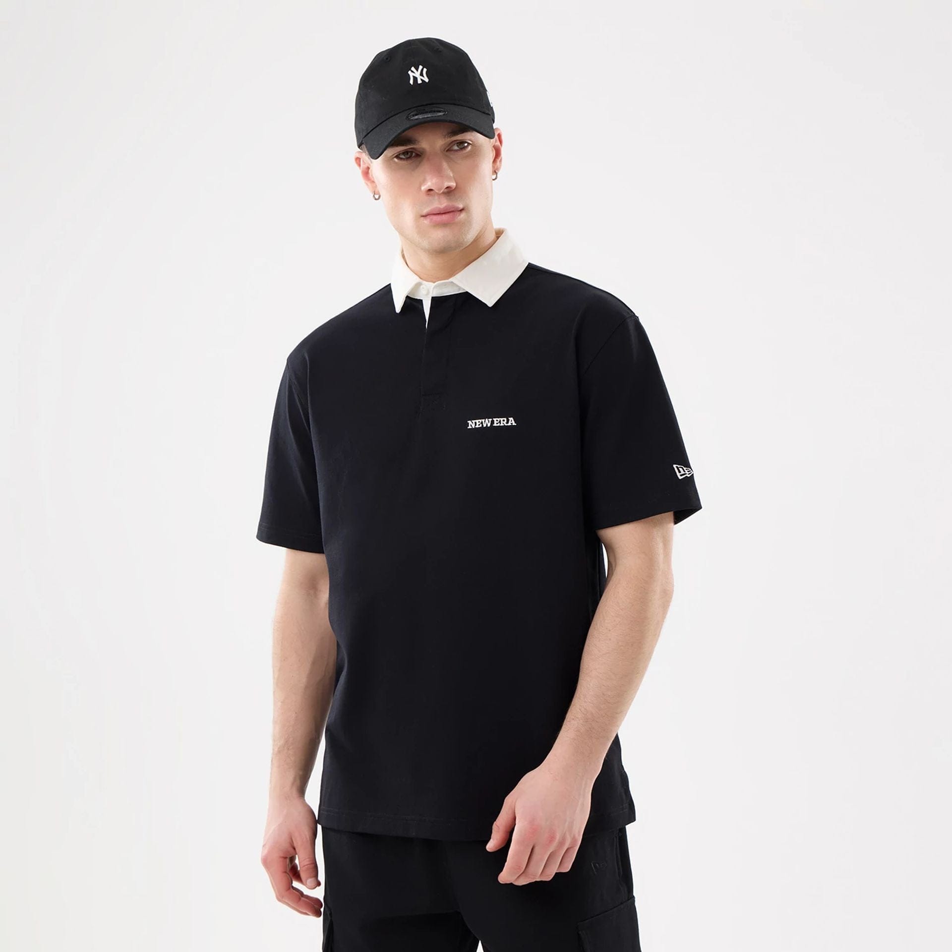 The model is wearing this New Era Short Sleeve Rugby Shirt in black. 1