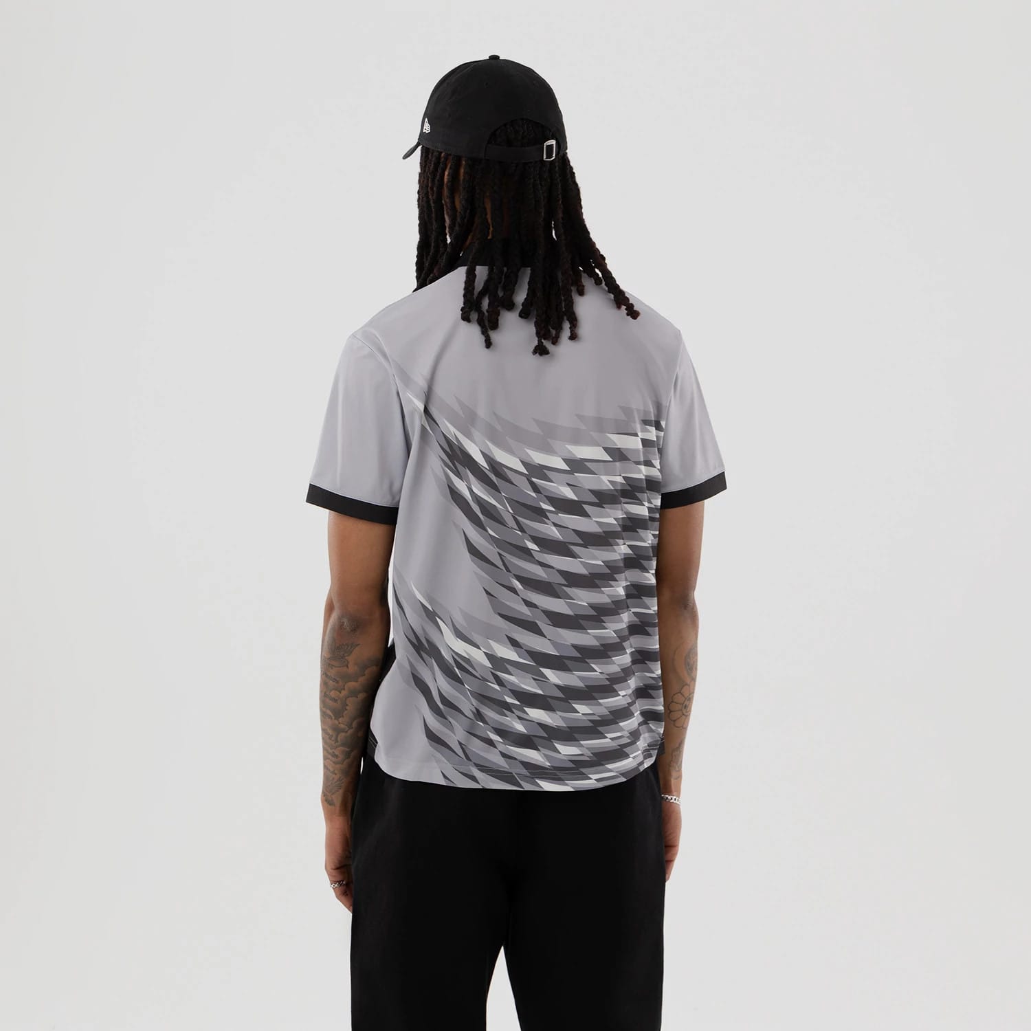 The model is wearing this New Era Grid Polo T-Shirt in grey. 2