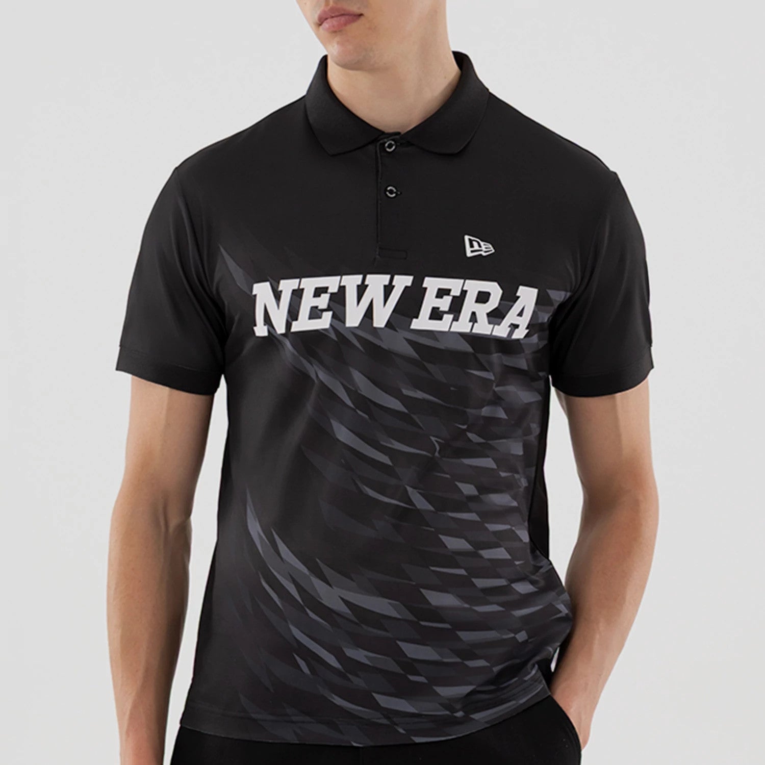 The model is wearing this New Era Grid Polo T-Shirt in black. 3