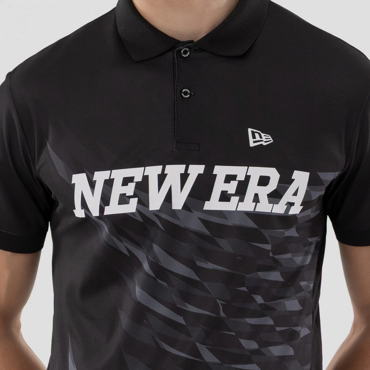 The model is wearing this New Era Grid Polo T-Shirt in black. 4