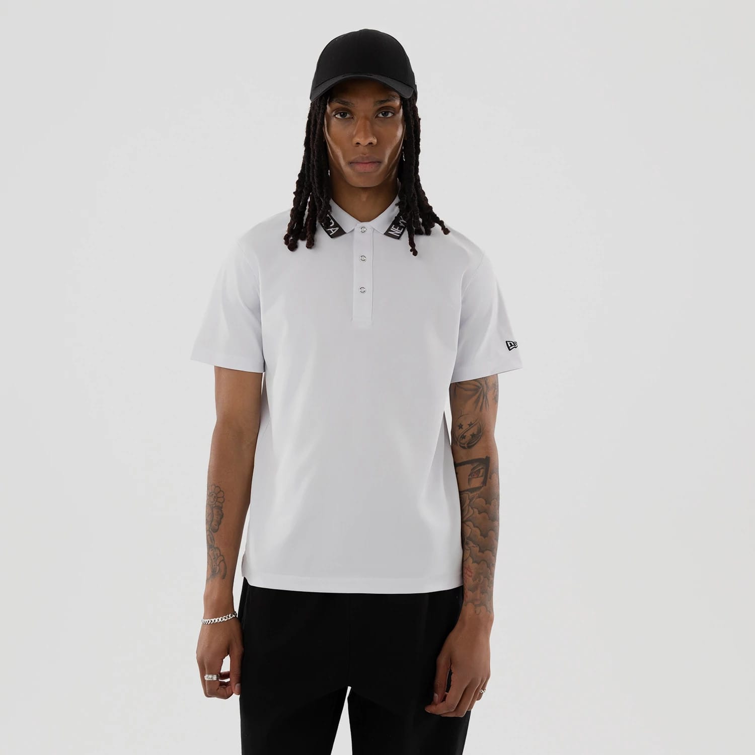 The model is wearing this New Era Kanoko Polo T-Shirt in white. 1