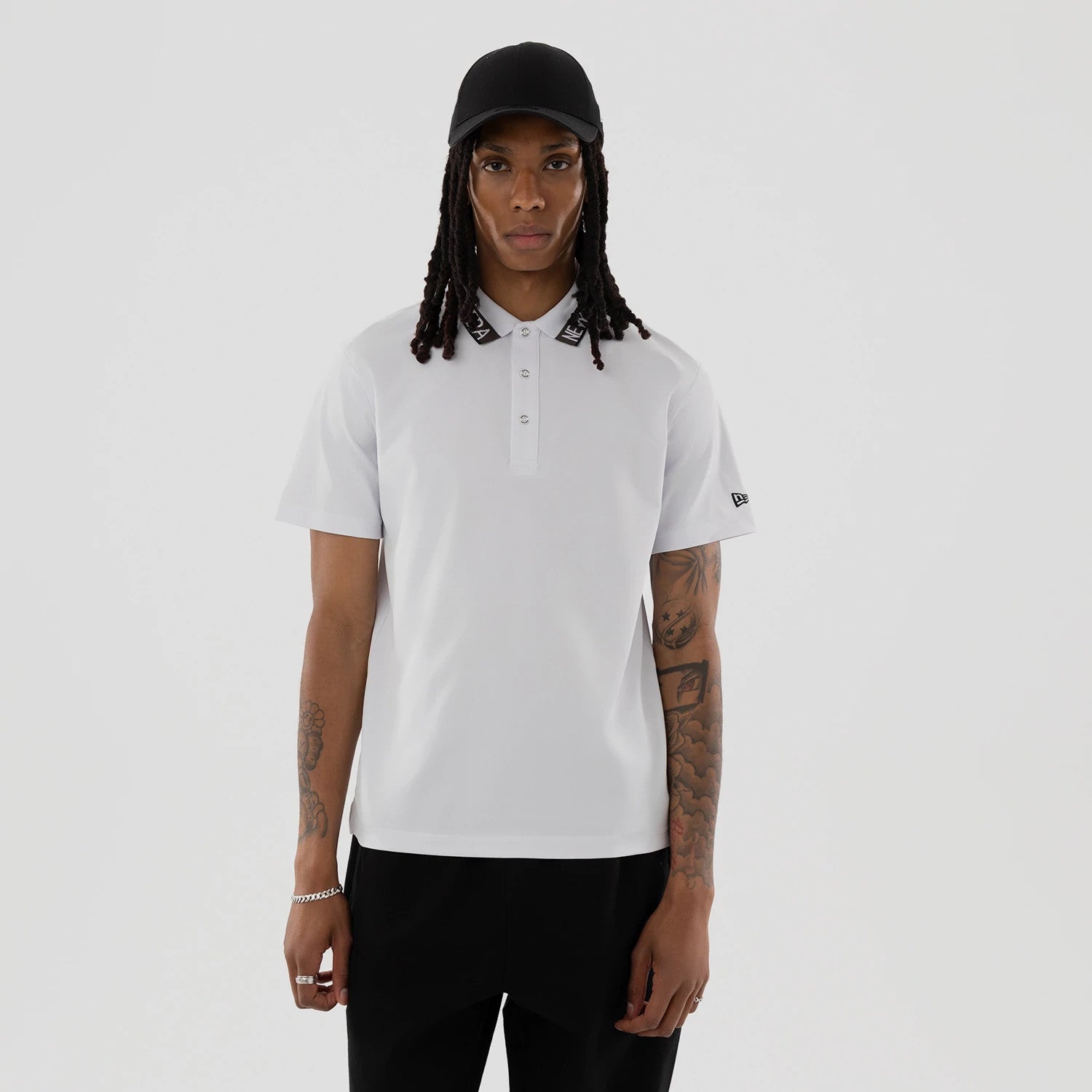 The model is wearing this New Era Kanoko Polo T-Shirt in white. 1