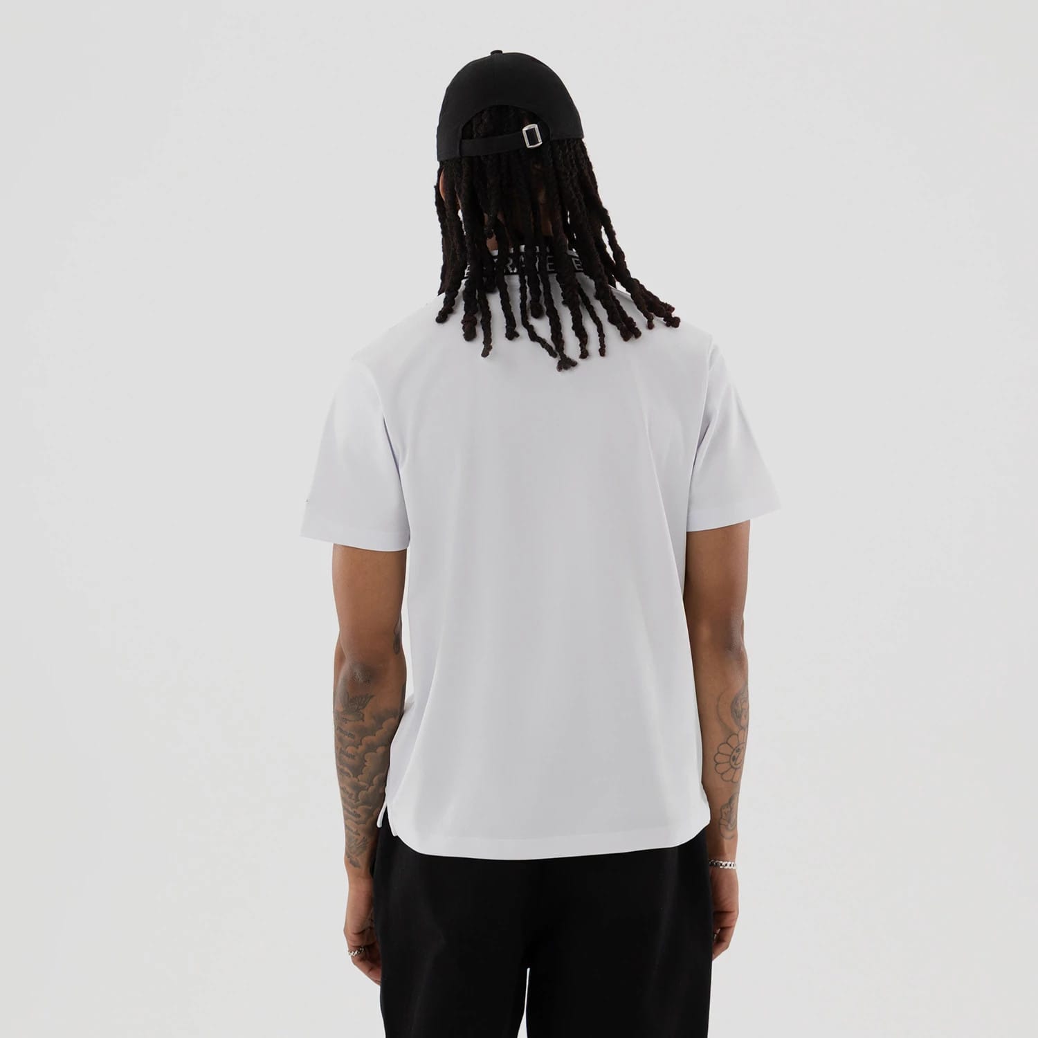 The model is wearing this New Era Kanoko Polo T-Shirt in white. 2