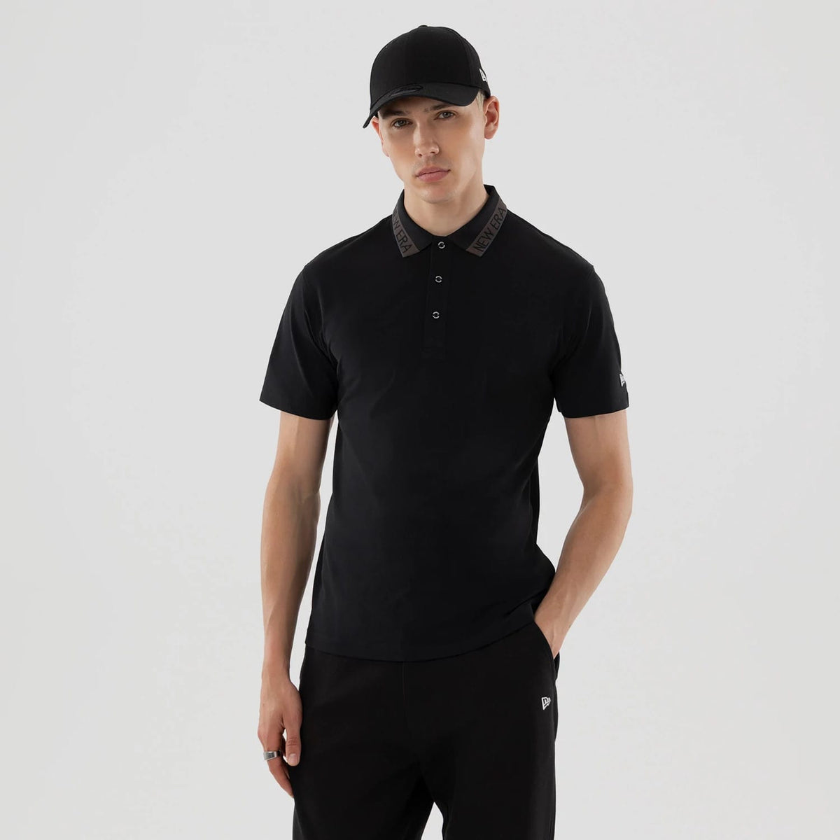 The model is wearing this New Era Kanoko Polo T-Shirt in black. 1