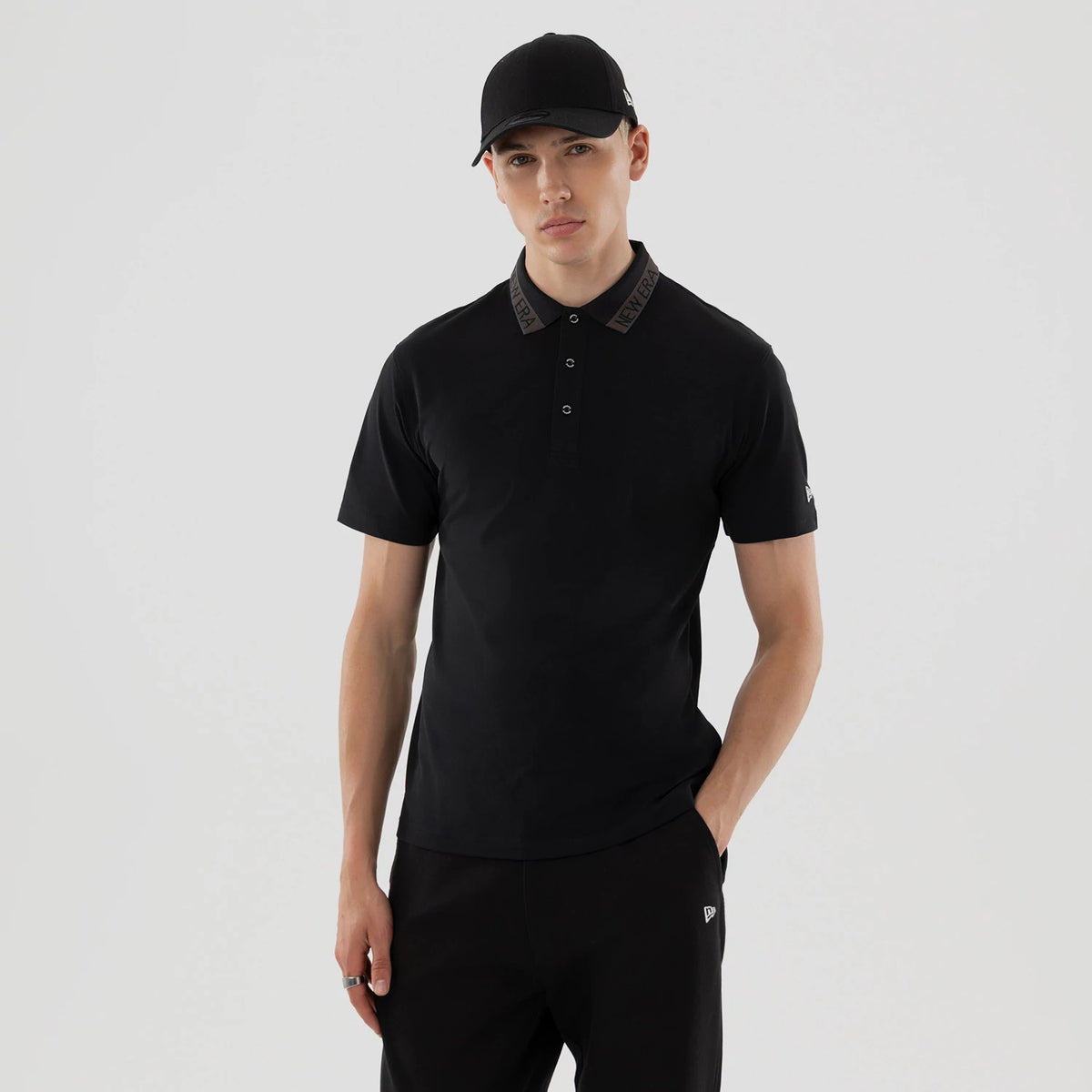 The model is wearing this New Era Kanoko Polo T-Shirt in black. 1