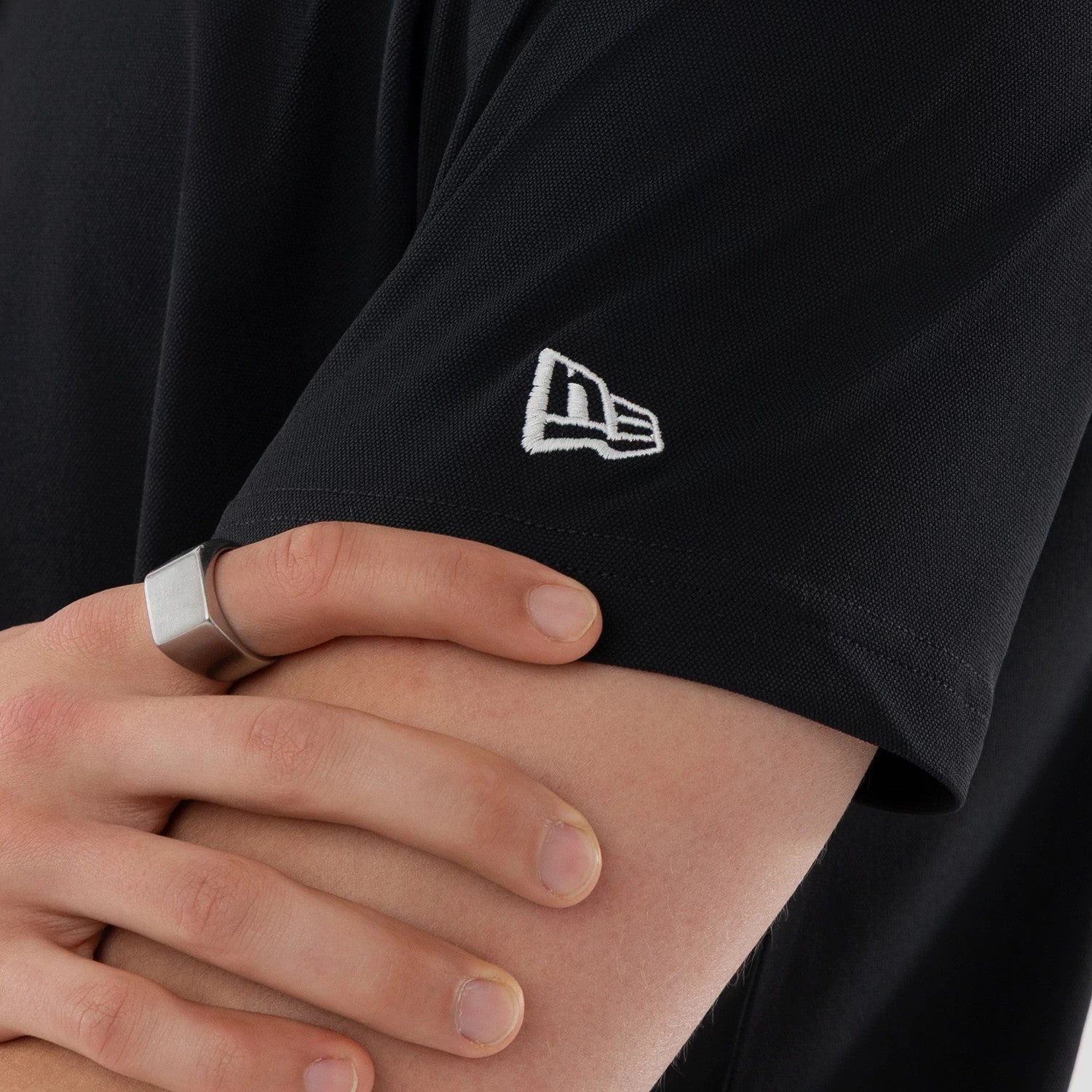 The model is wearing this New Era Kanoko Polo T-Shirt in black. 4
