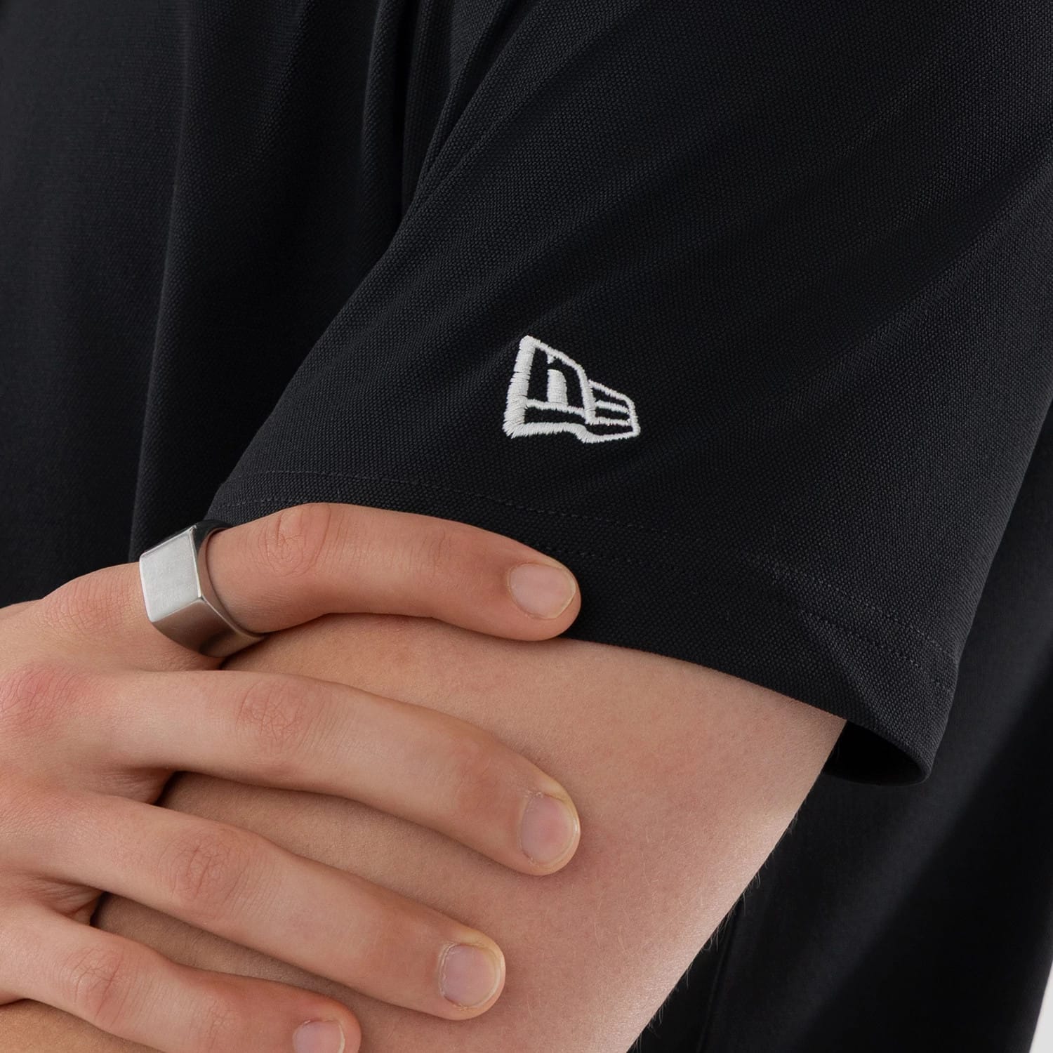 The model is wearing this New Era Kanoko Polo T-Shirt in black. 4