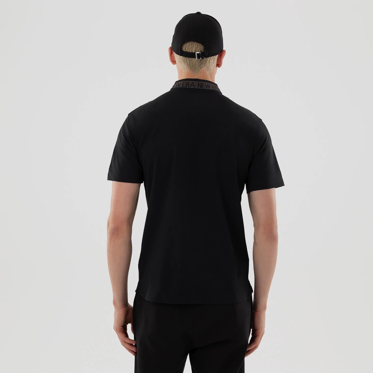The model is wearing this New Era Kanoko Polo T-Shirt in black. 2