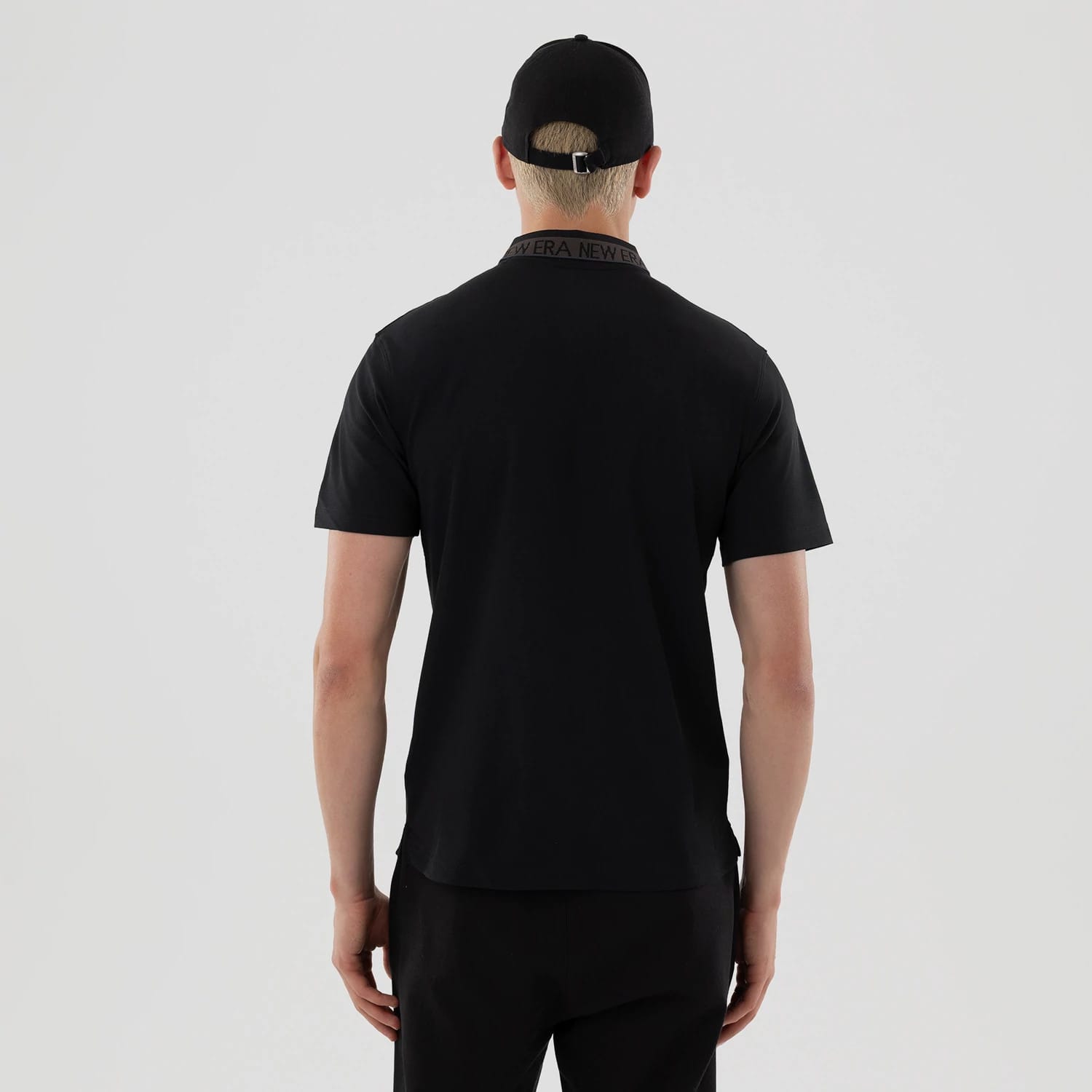 The model is wearing this New Era Kanoko Polo T-Shirt in black. 2